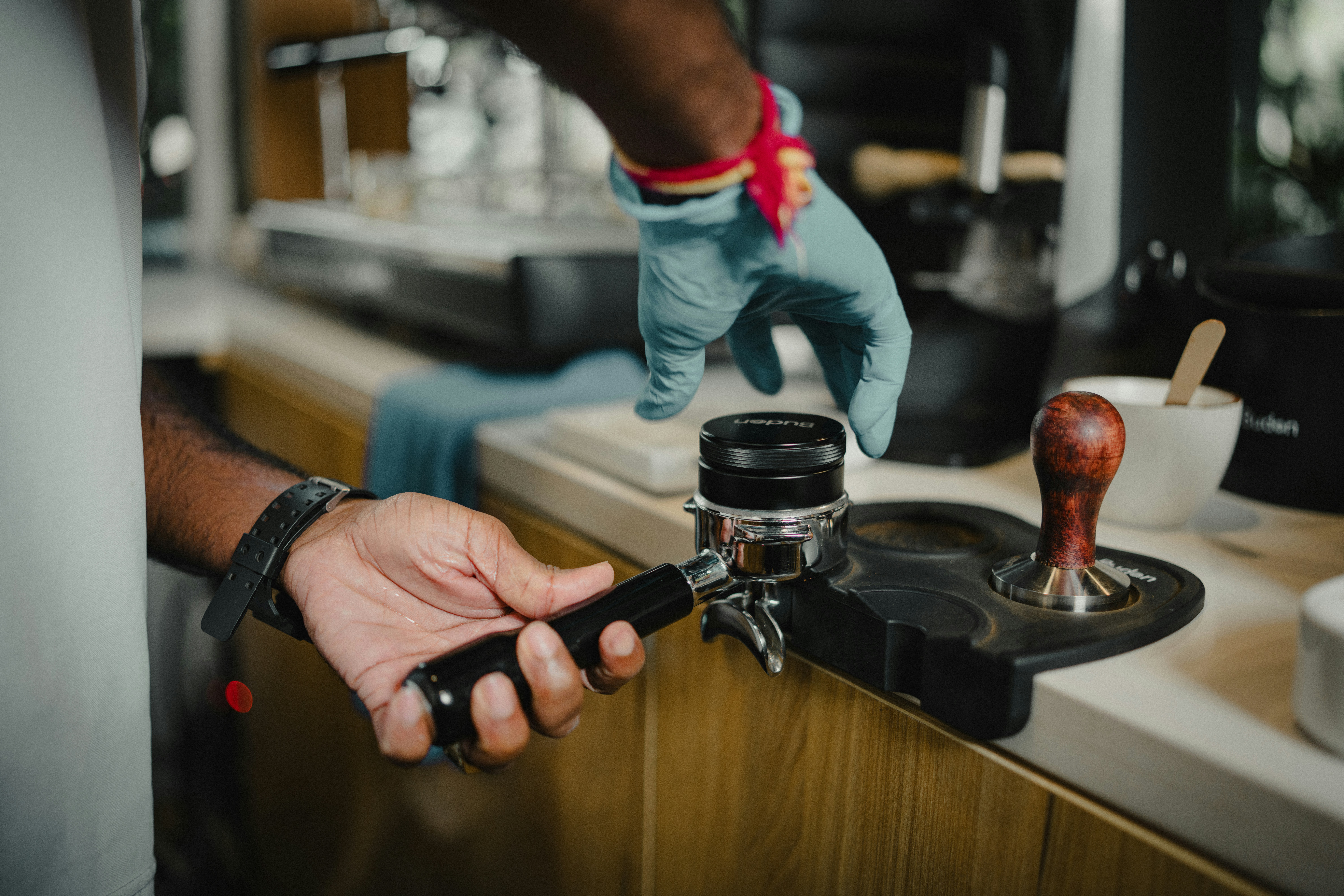 Barista tamping coffee grounds in a portafilter