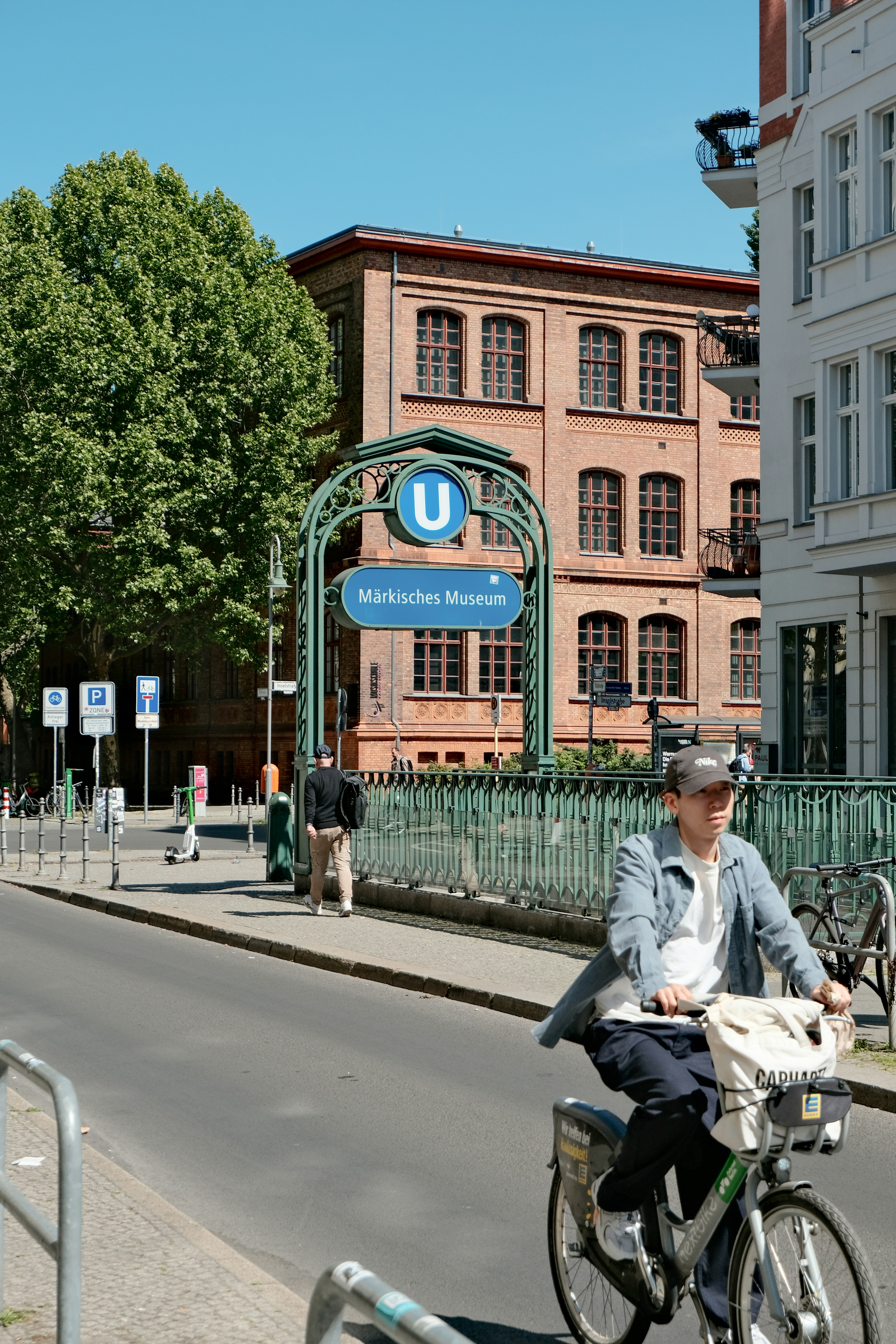 Cyclist passes u-bahn station entrance in berlin.