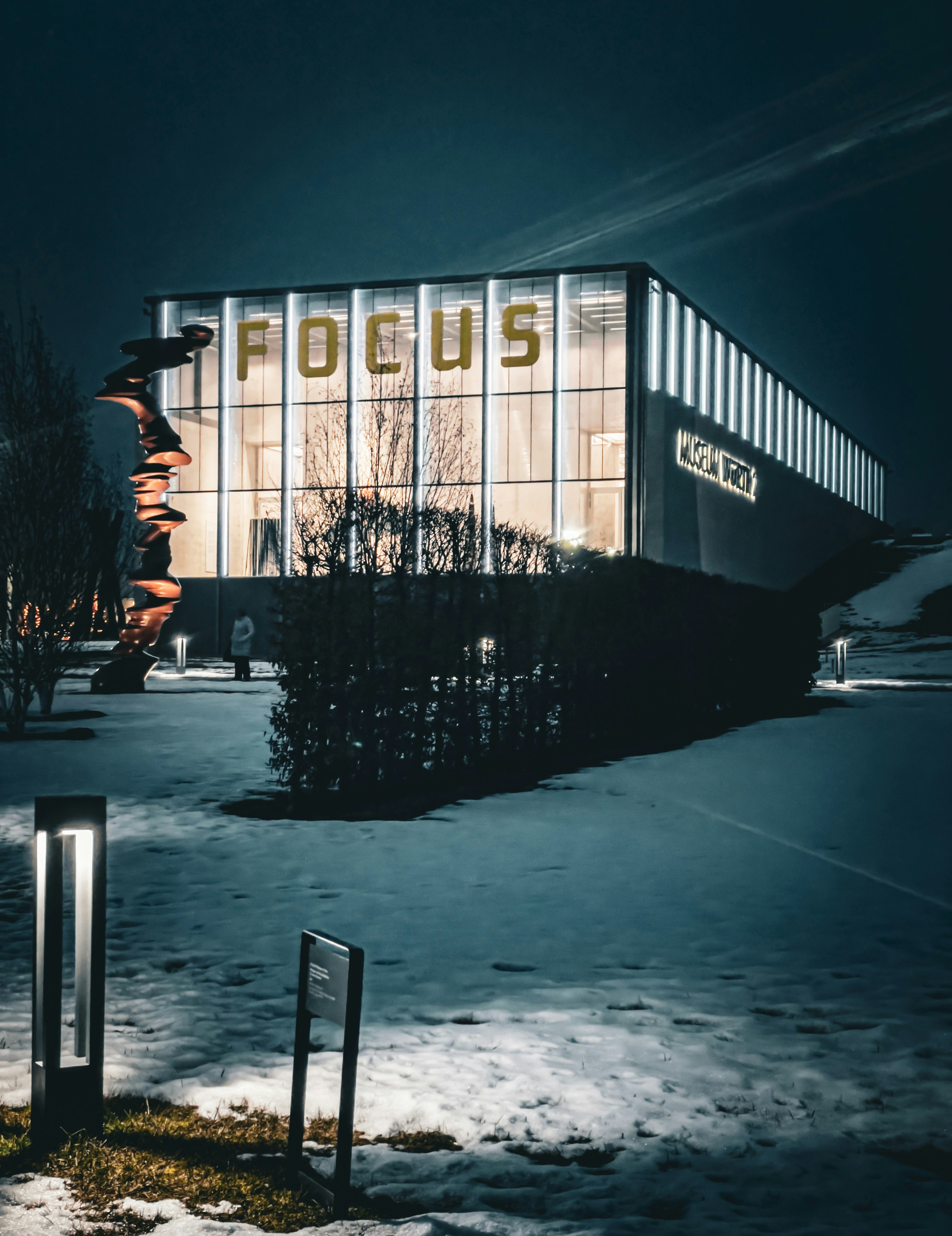 Modernes Gebäude mit "Fokus"-Schild nachts