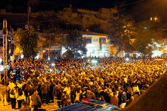 A large crowd gathered in a street at night.