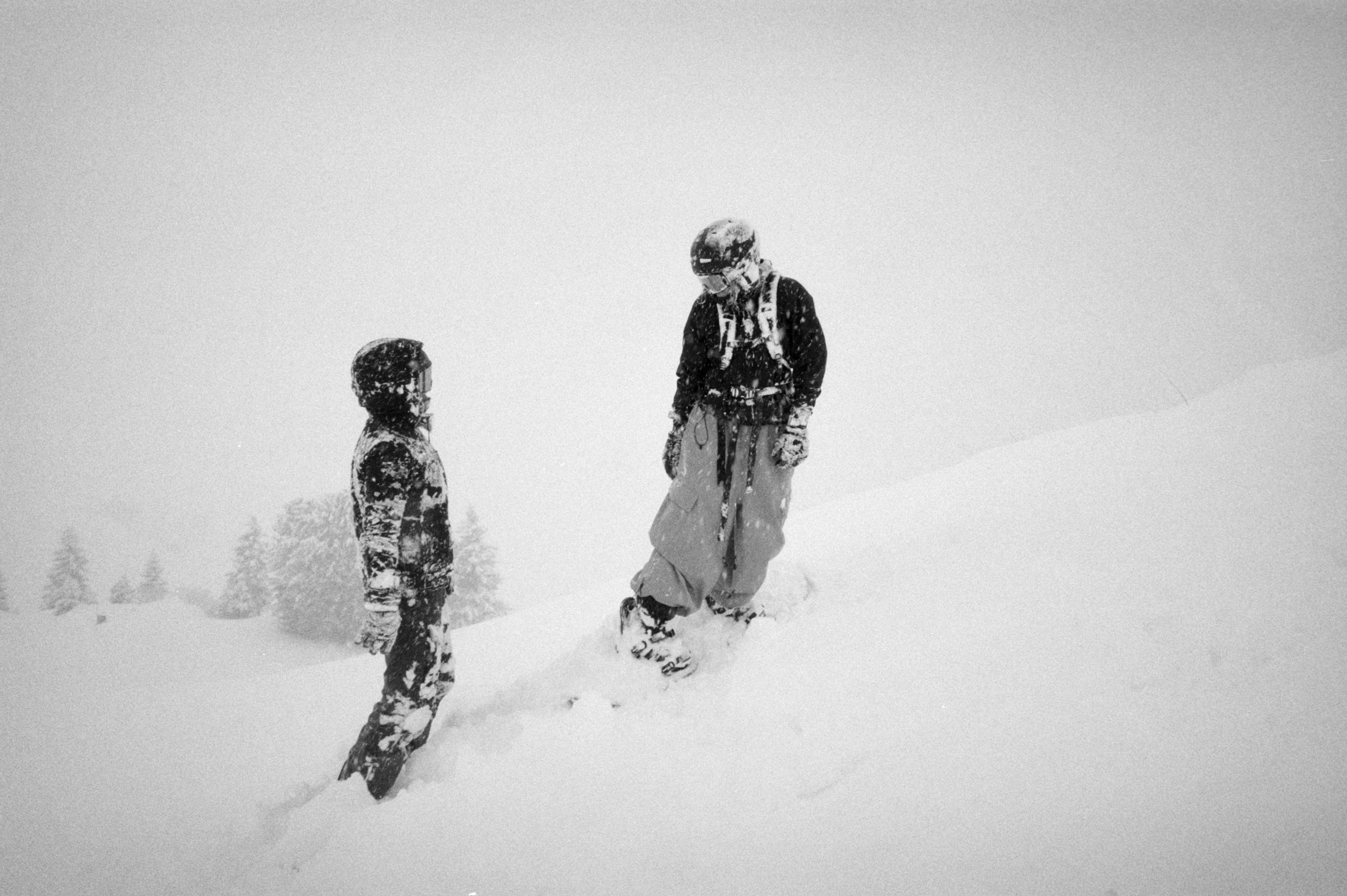 Two snowboarders in a snowy landscape