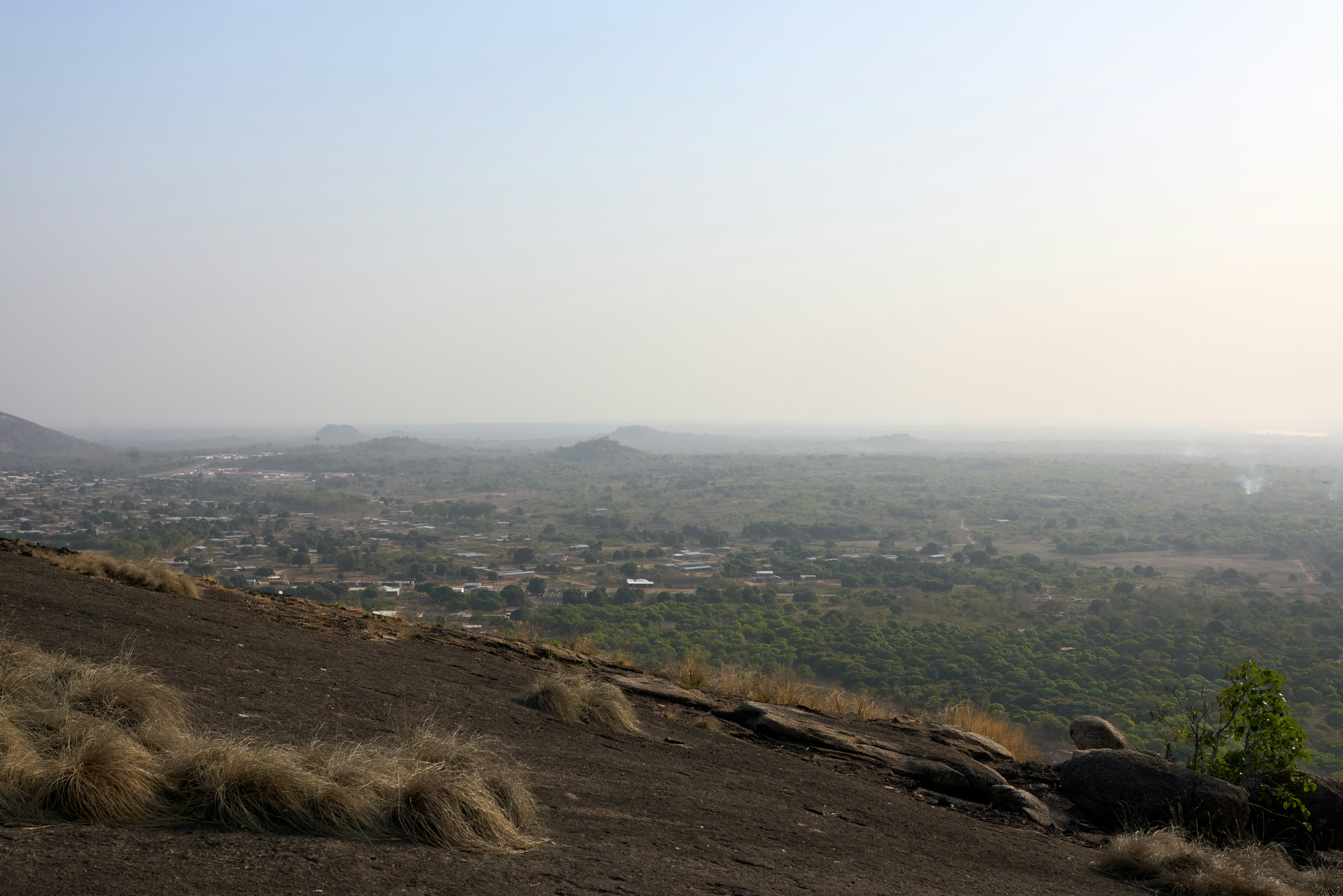 A hazy landscape view from a rocky hill