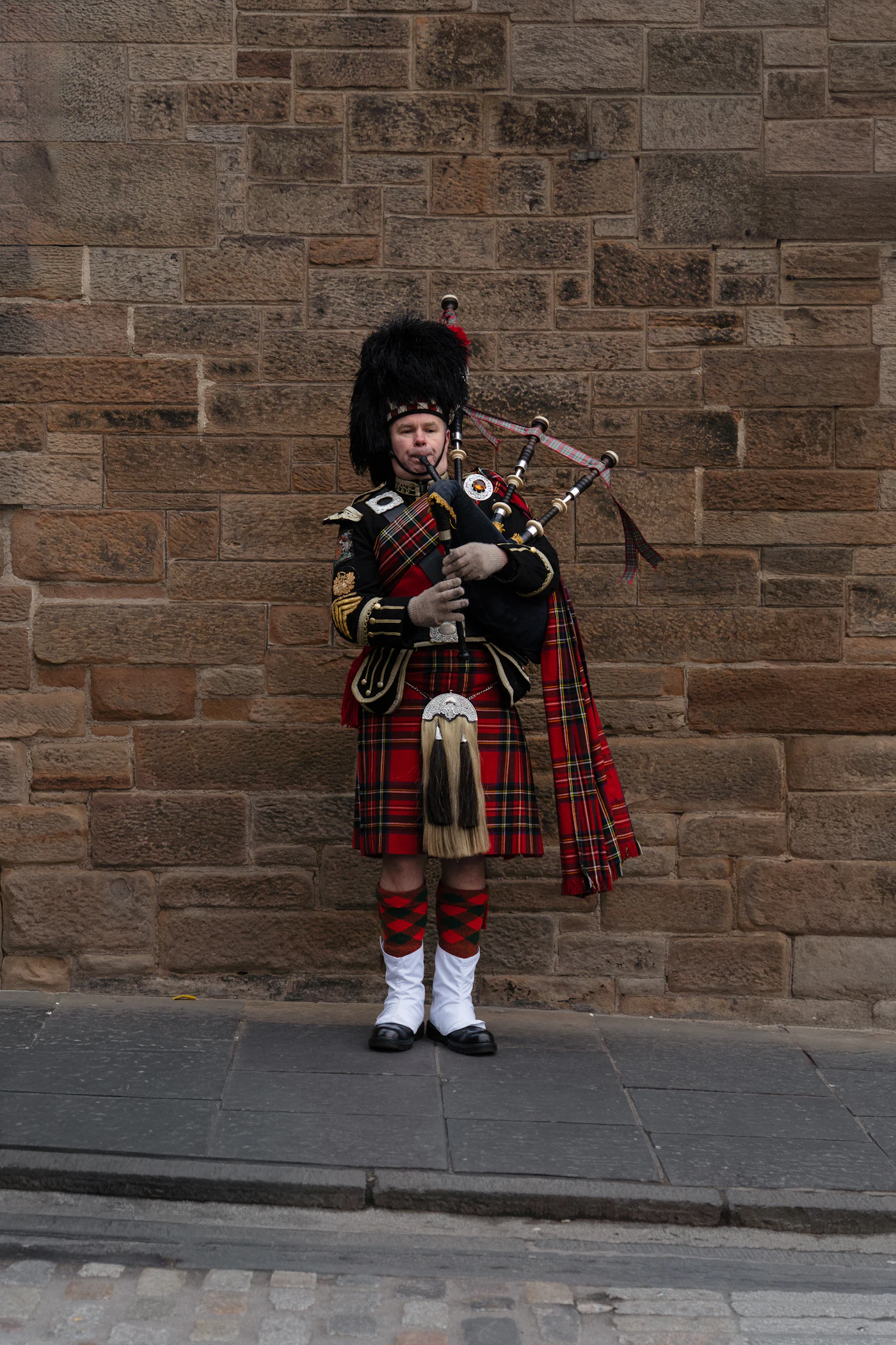 Bagpiper in a traditional Scottish kilt playing at a Highland games festival