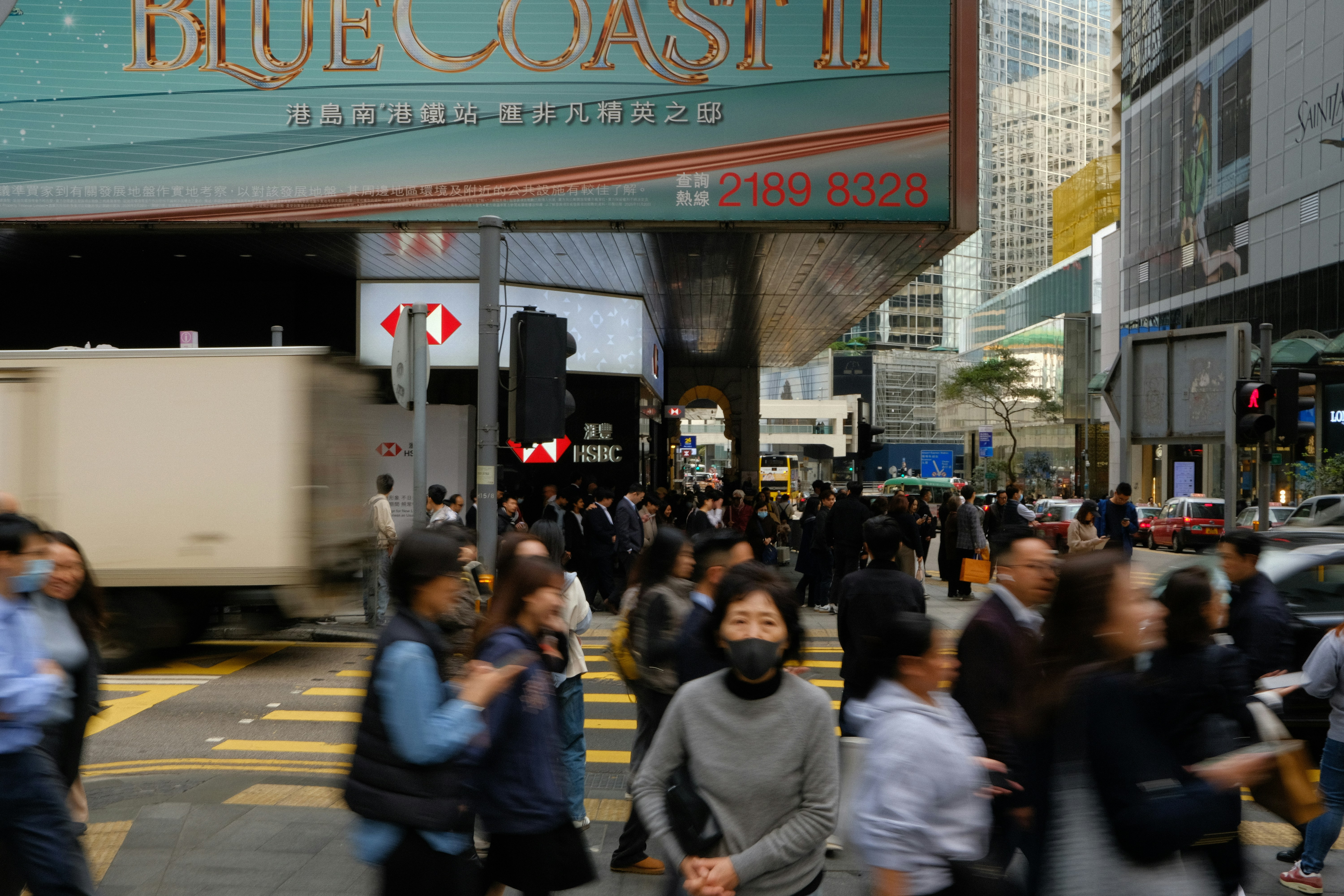 Crowd of people crossing a busy city street.