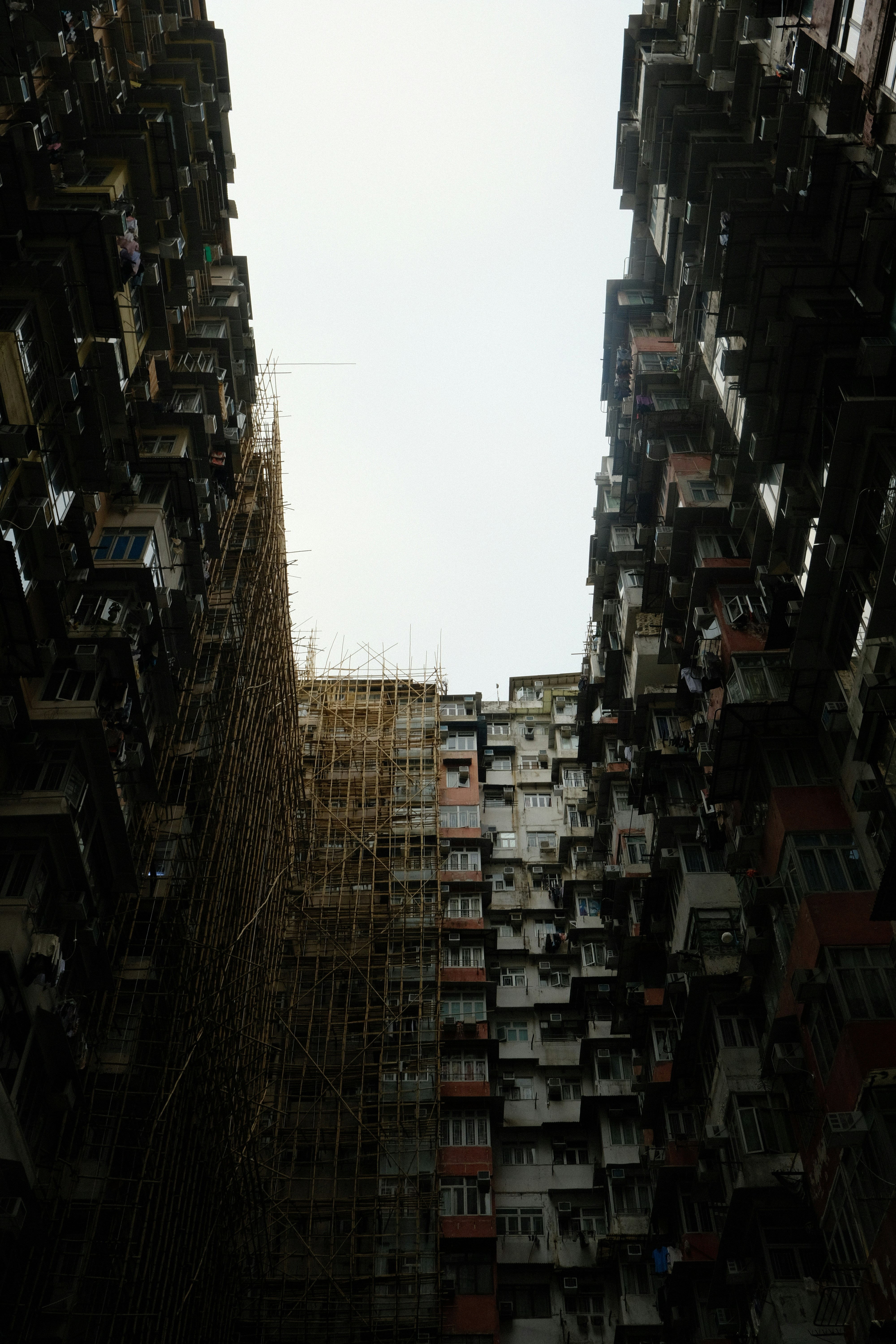 Dense apartment buildings with scaffolding against sky