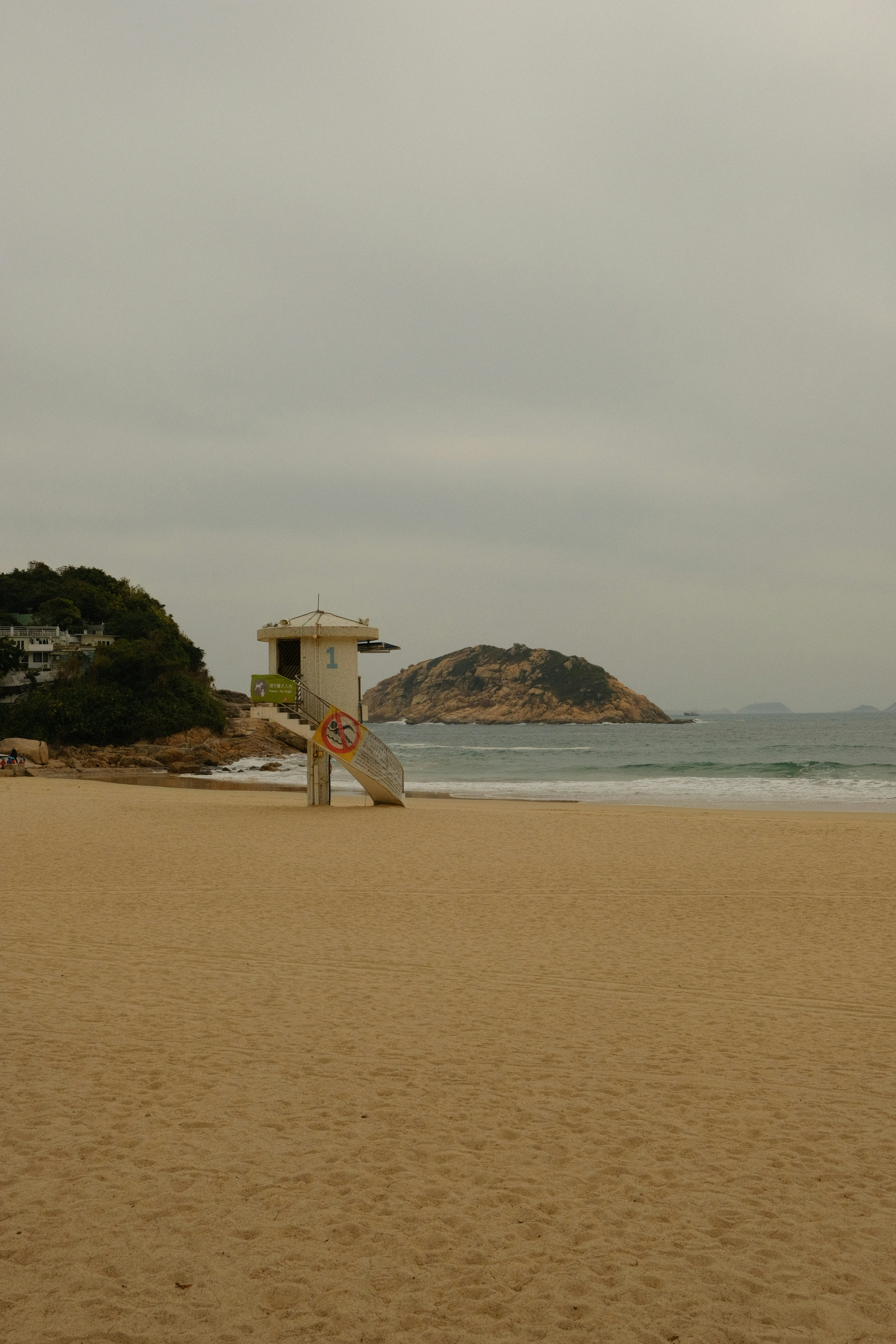 Lifeguard tower on a sandy beach with island.