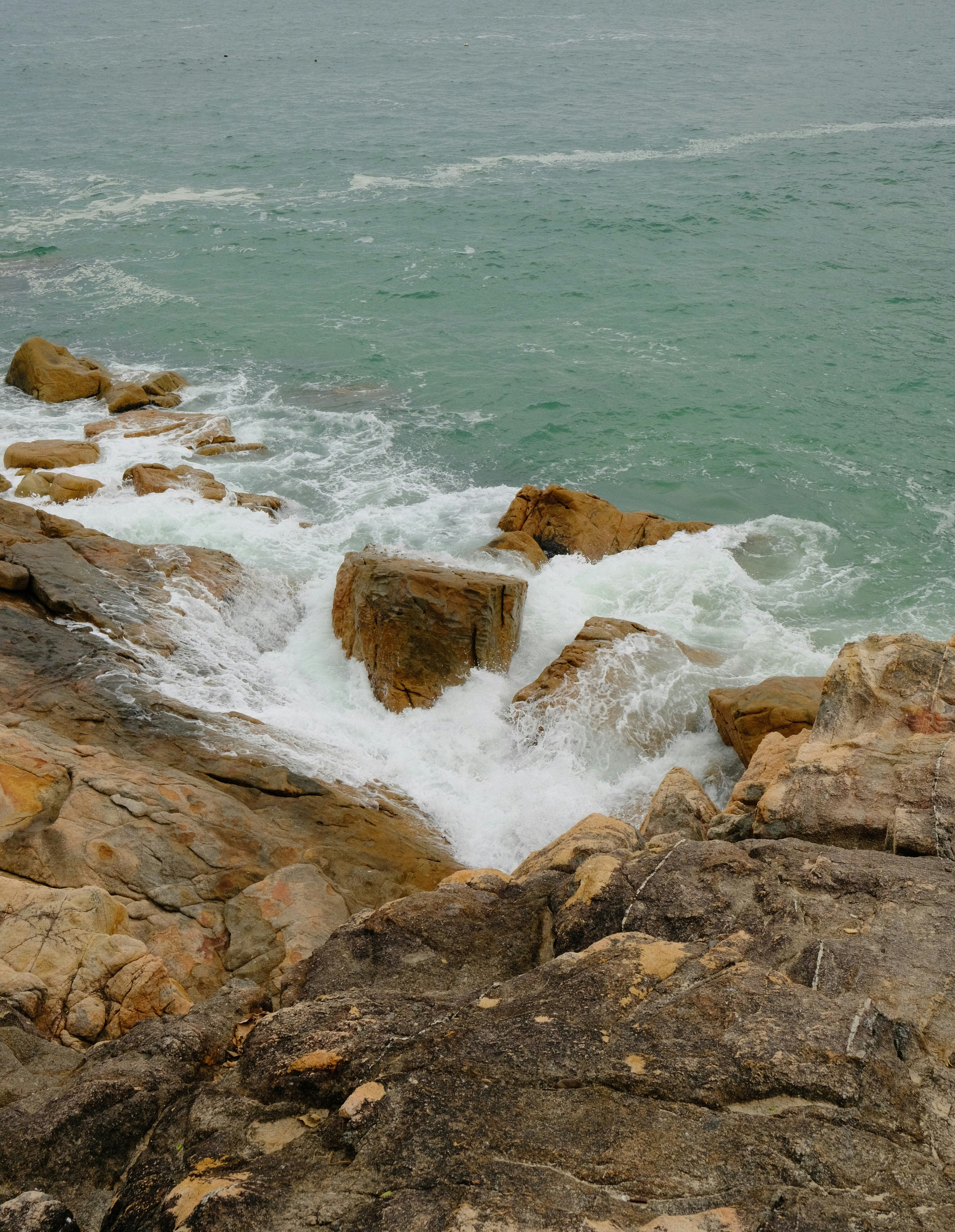 Waves crashing against rocky shore on a cloudy day