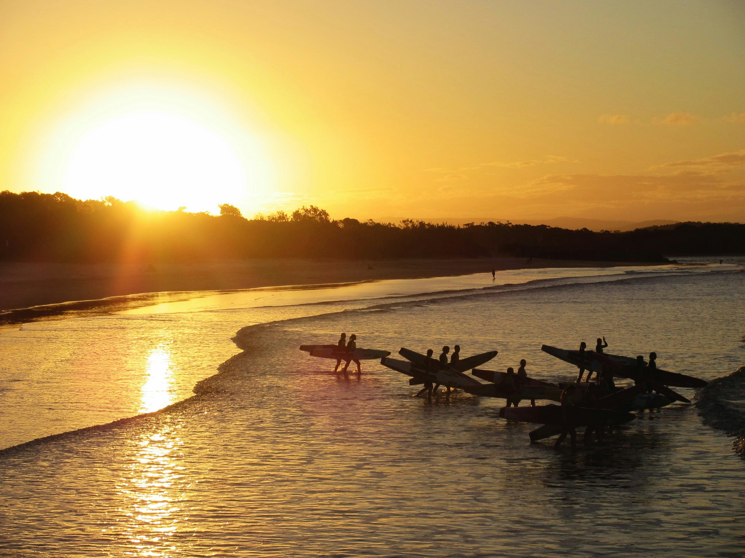 Les kayakistes se préparent à la pagaie au coucher du soleil sur la plage.
