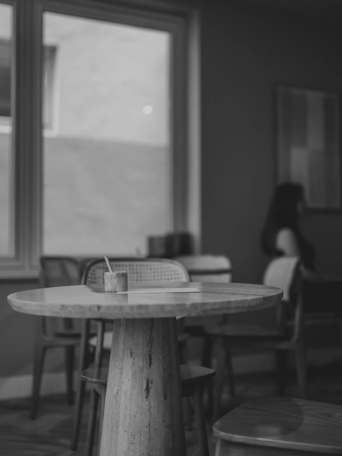 A cozy café interior with a coffee cup on a wooden table near a window