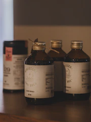 Three brown bottles with labels on a wooden surface.