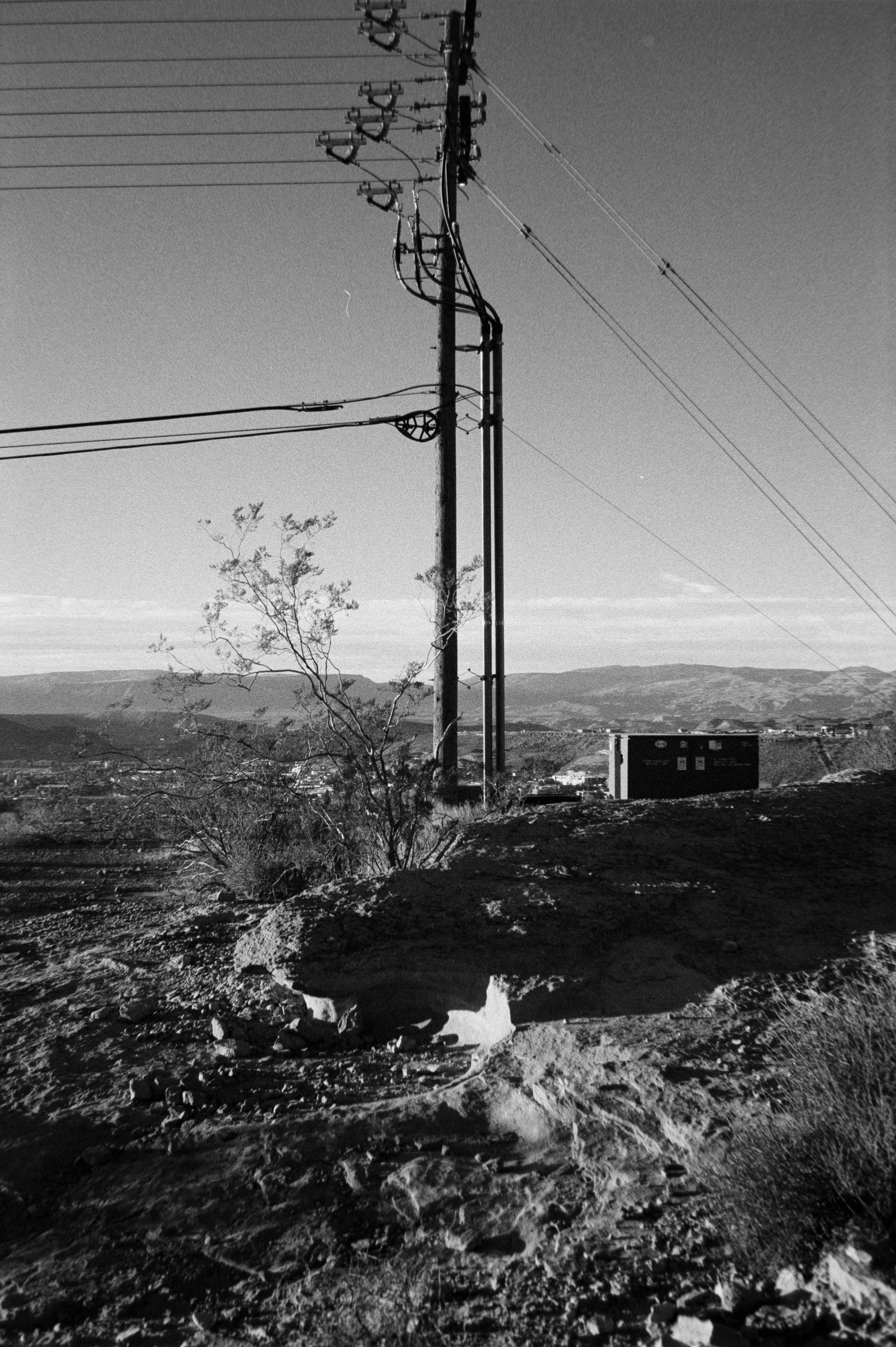 Power lines stretch across a barren, rocky landscape.
