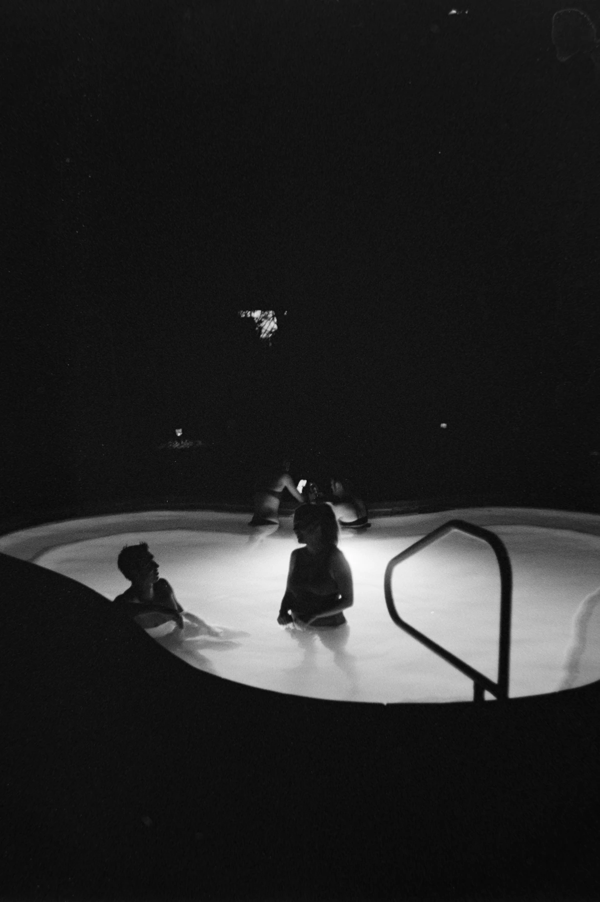 People relaxing in a hot tub at night