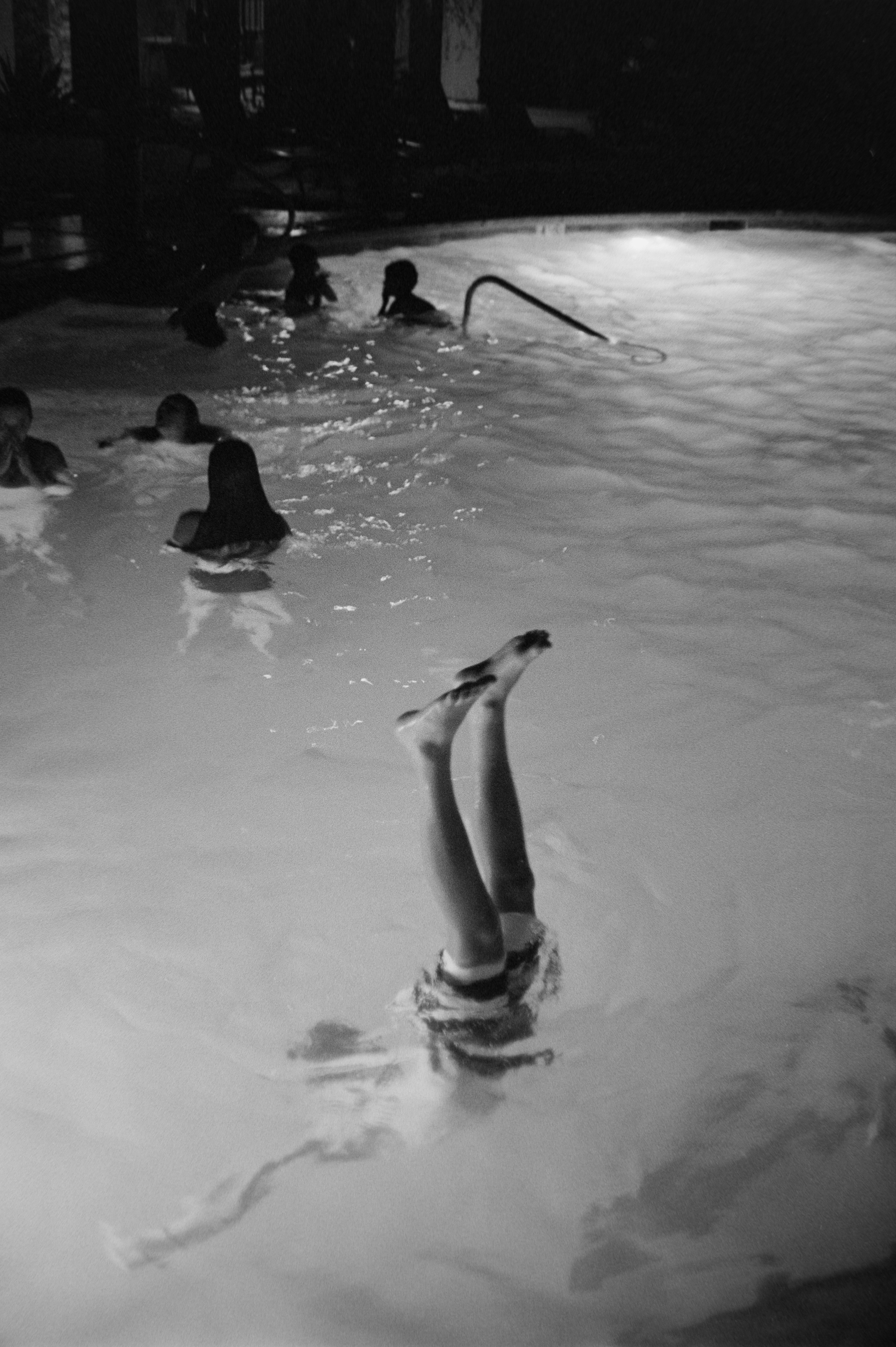 Children playing in a swimming pool at night