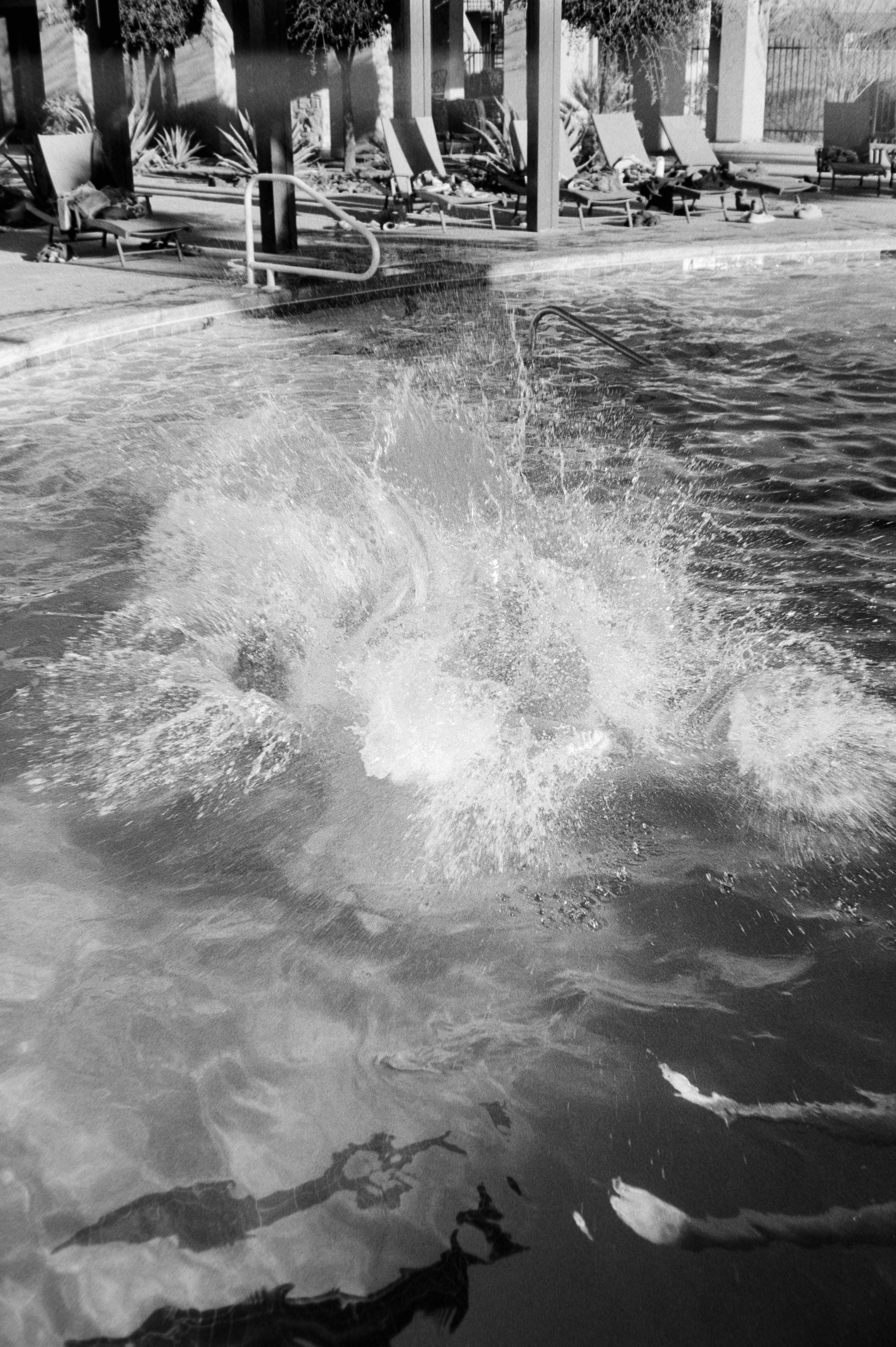 Une personne saute dans une piscine en créant un éclaboussurage.