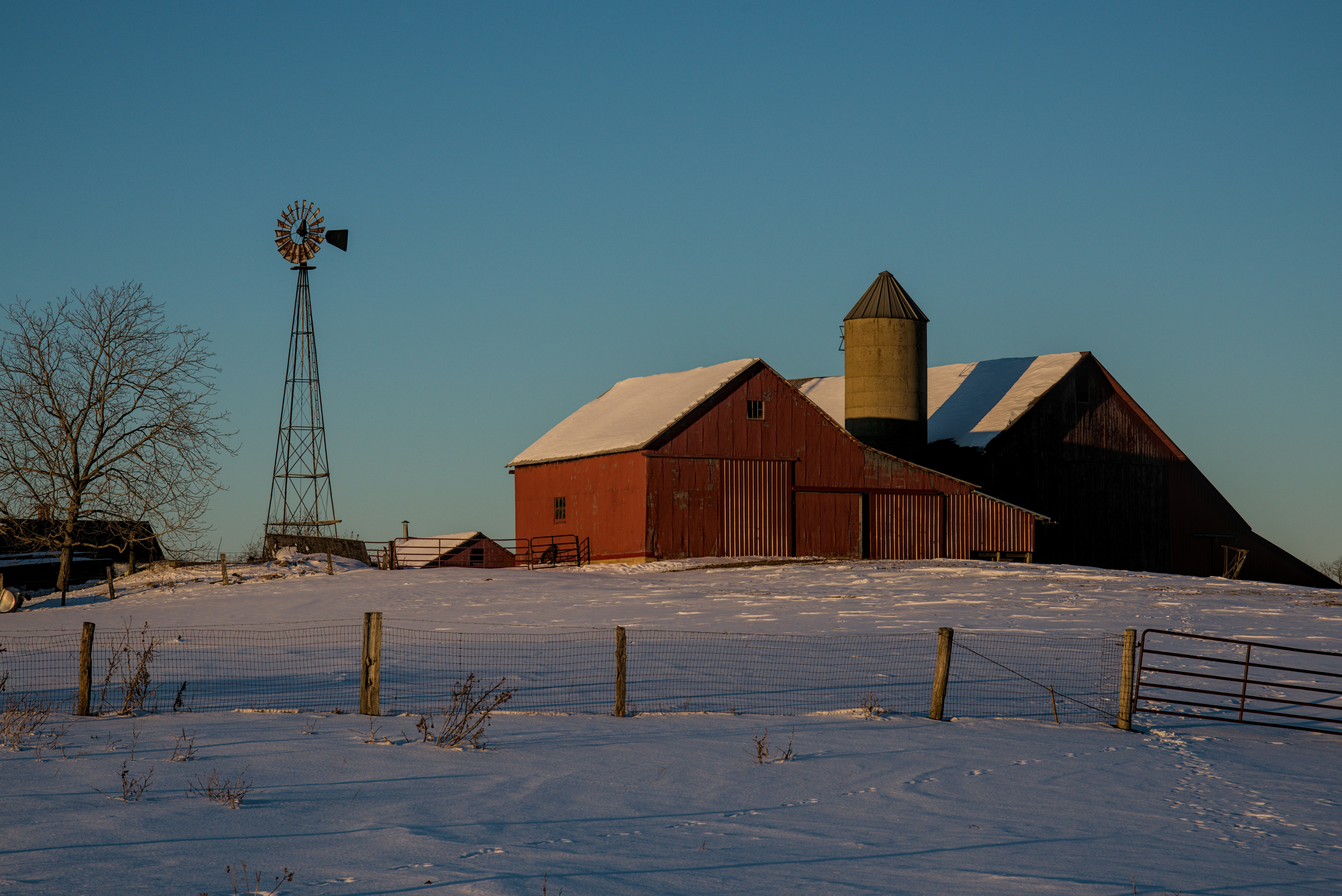 Red barn and windmill on a snowy winter day.
