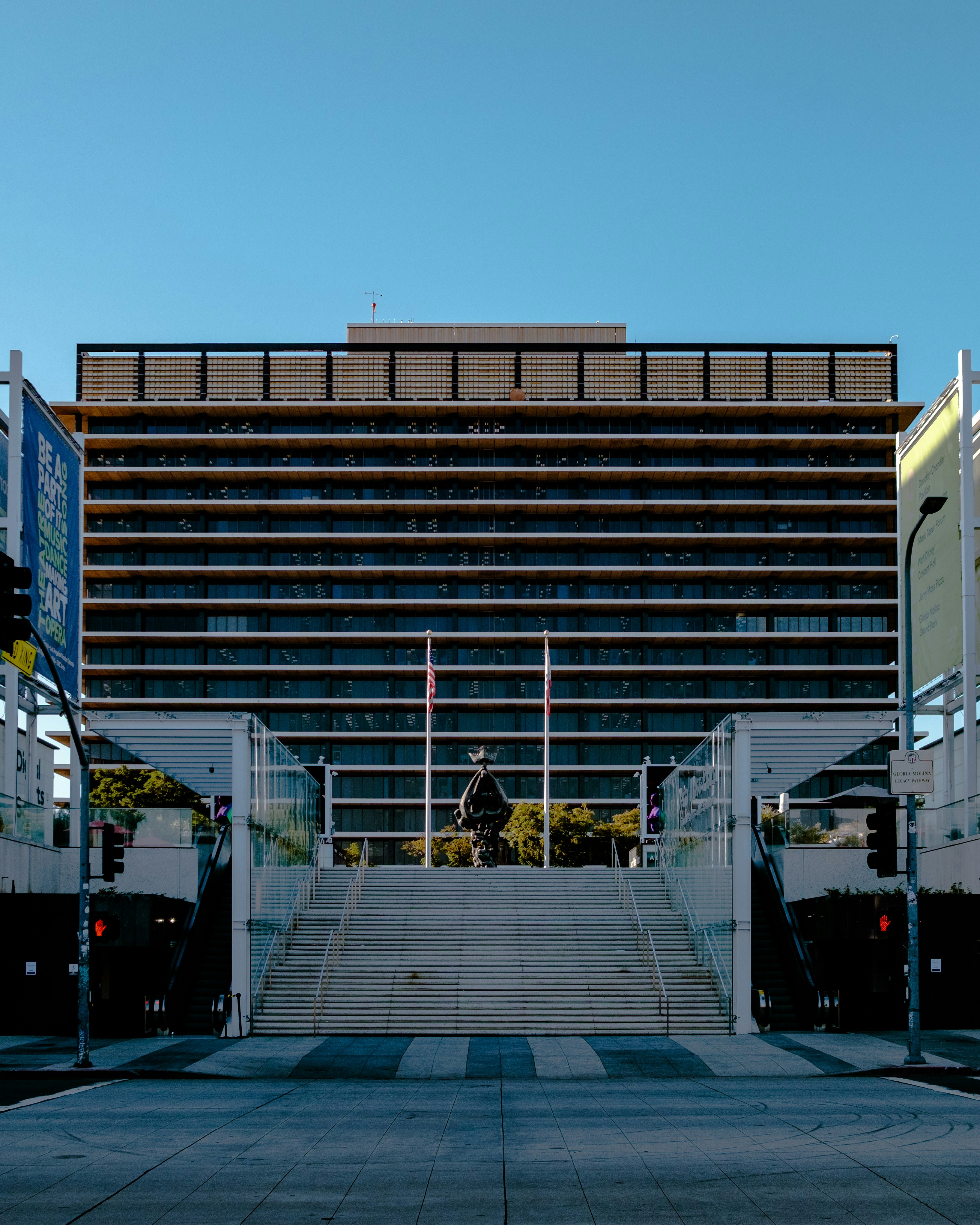 Modern building with a statue and wide stairs.