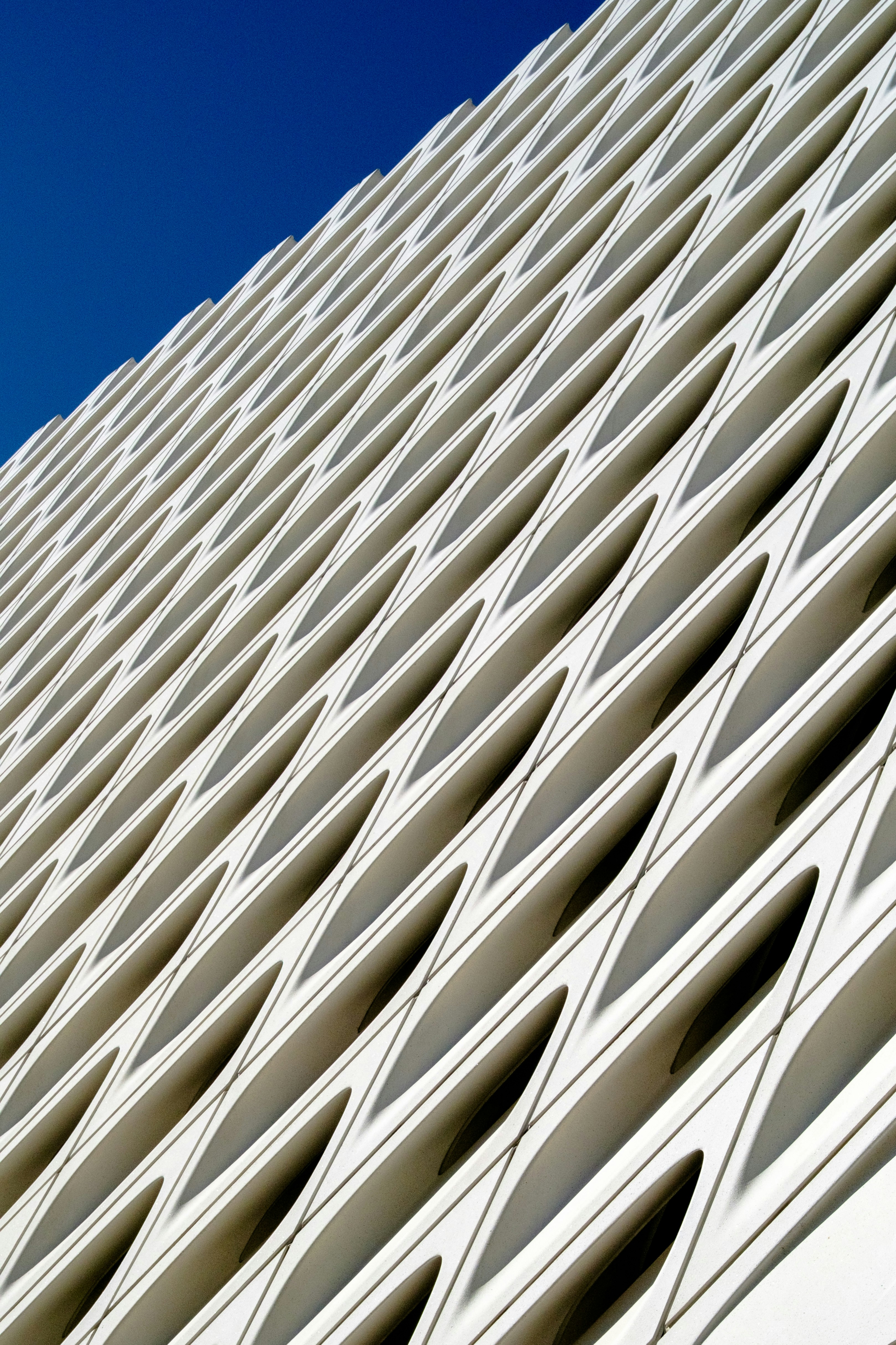 Modern building facade with geometric pattern against blue sky
