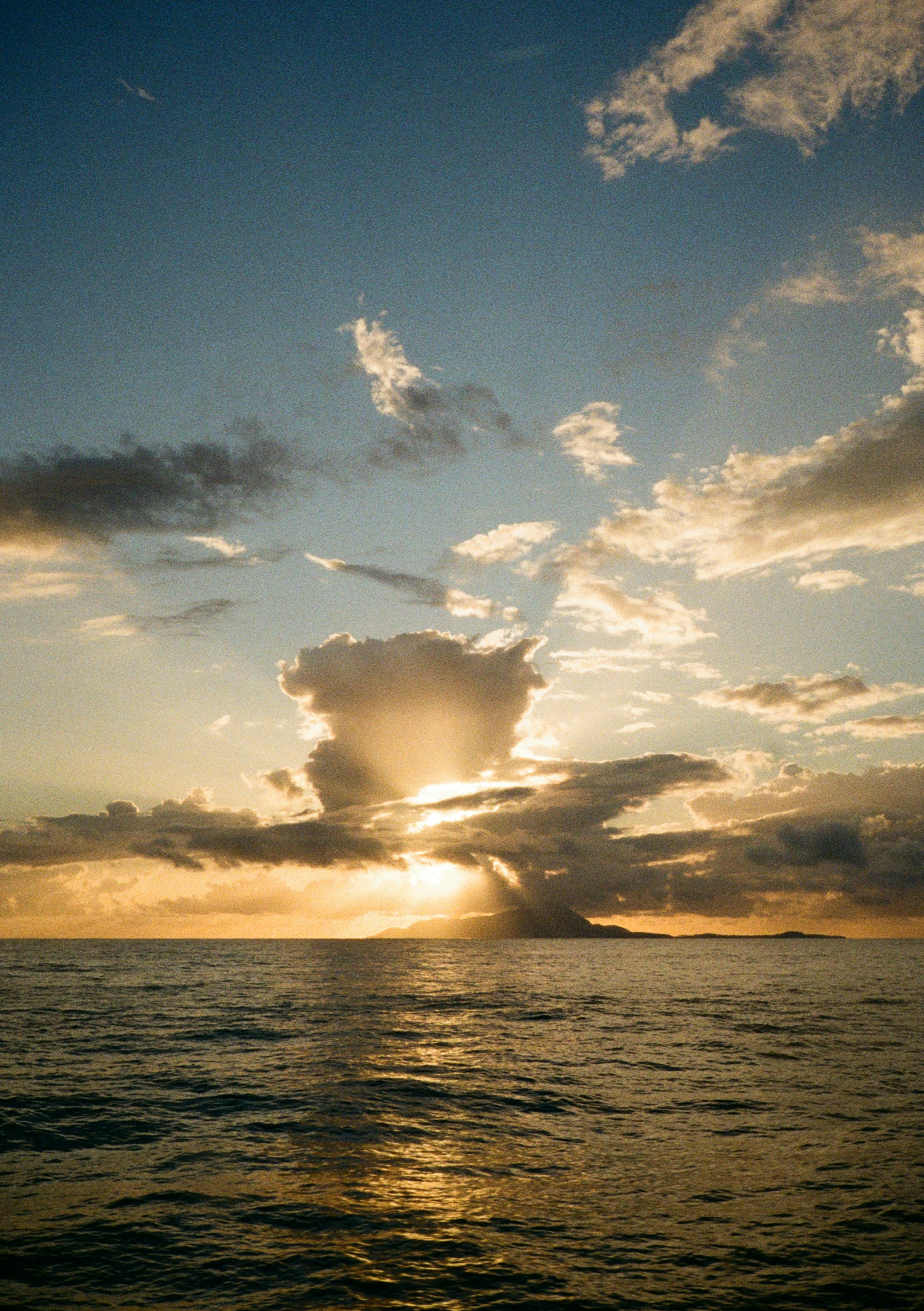 Die Sonne geht über dem Ozean unter mit dramatischen Wolken.