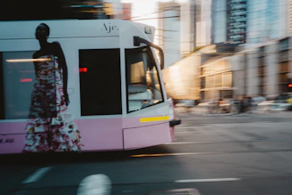 A tram with a fashion advertisement moves through city.