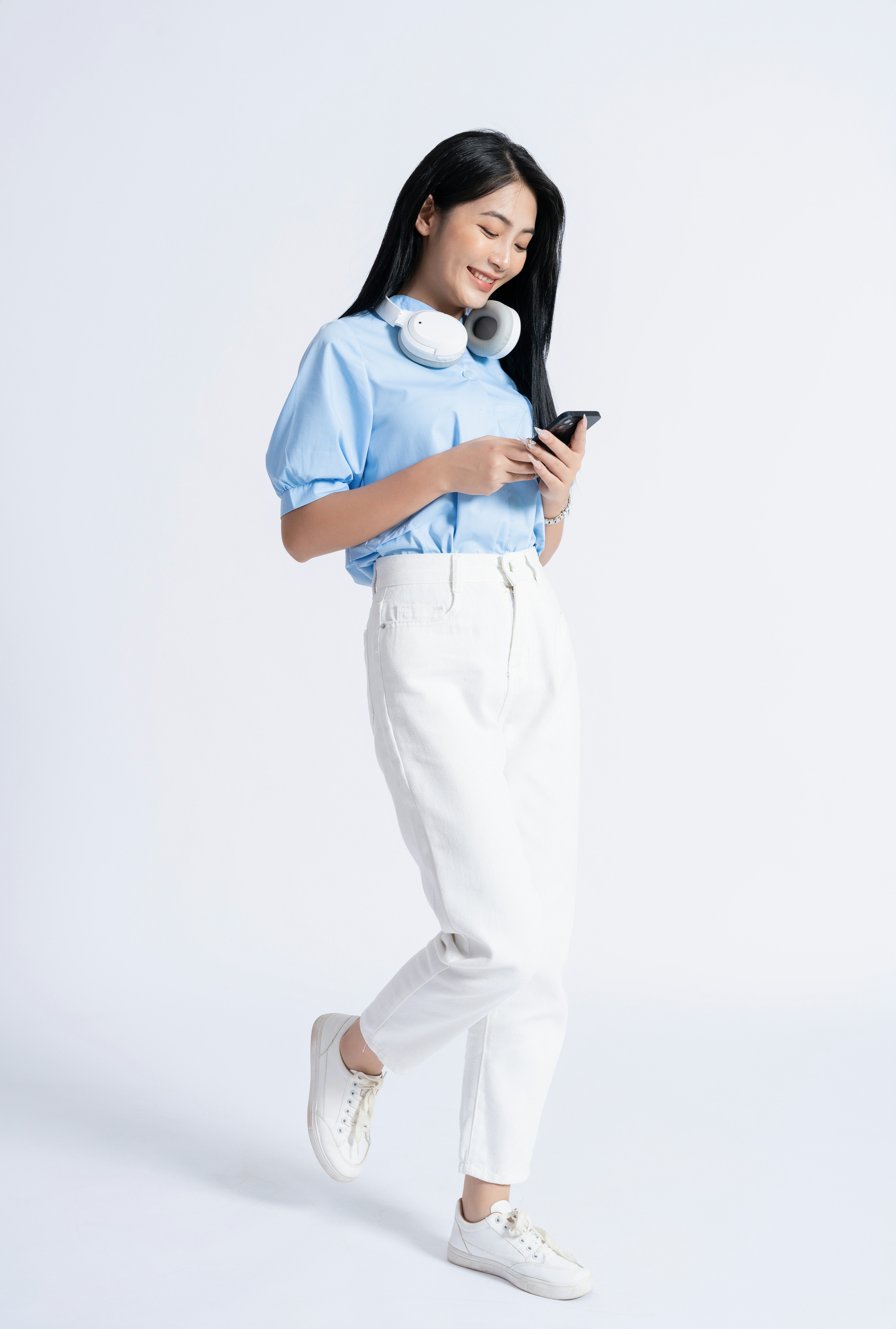 Young woman with headphones looking at her phone