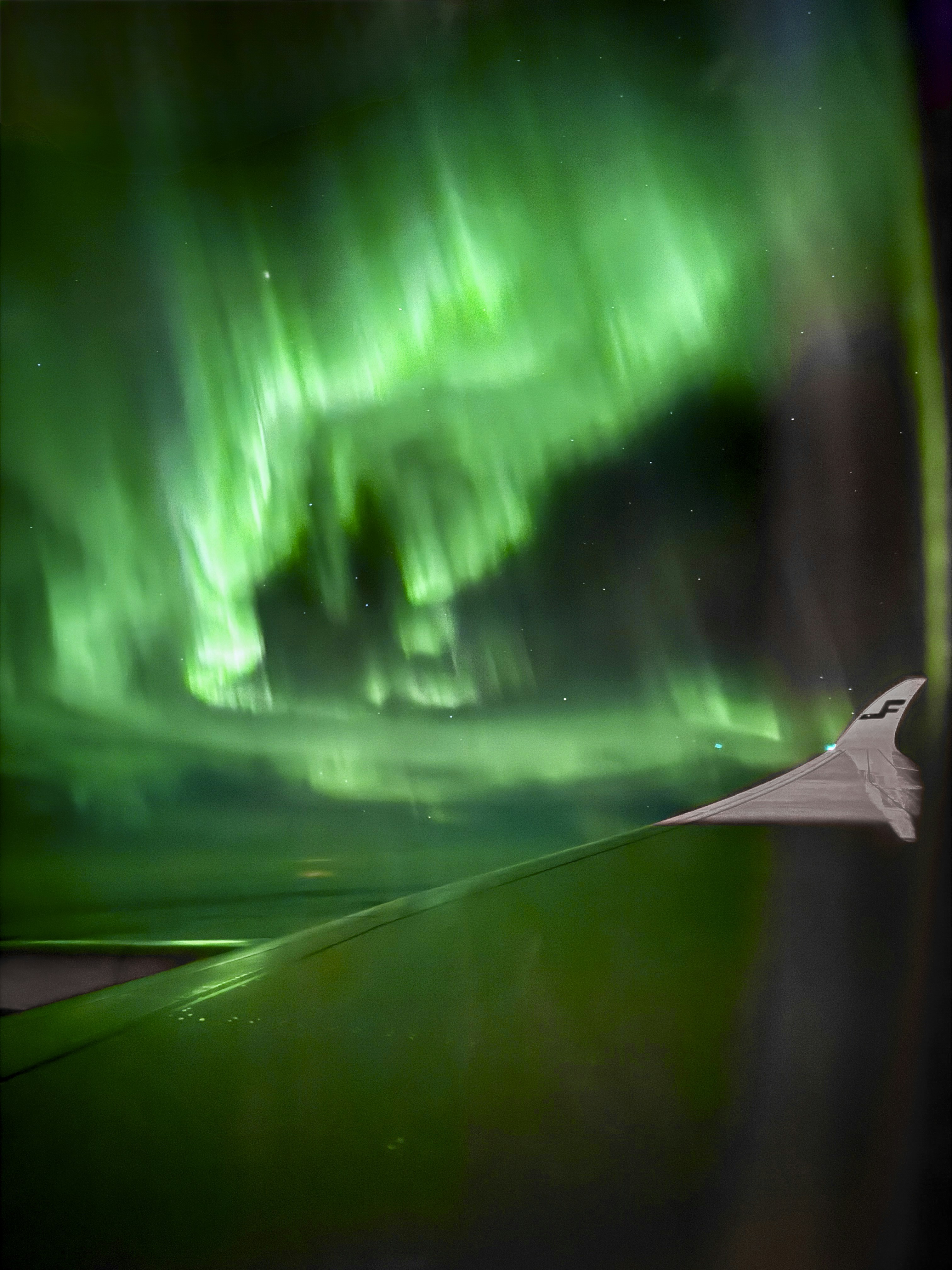Green aurora borealis seen from airplane window