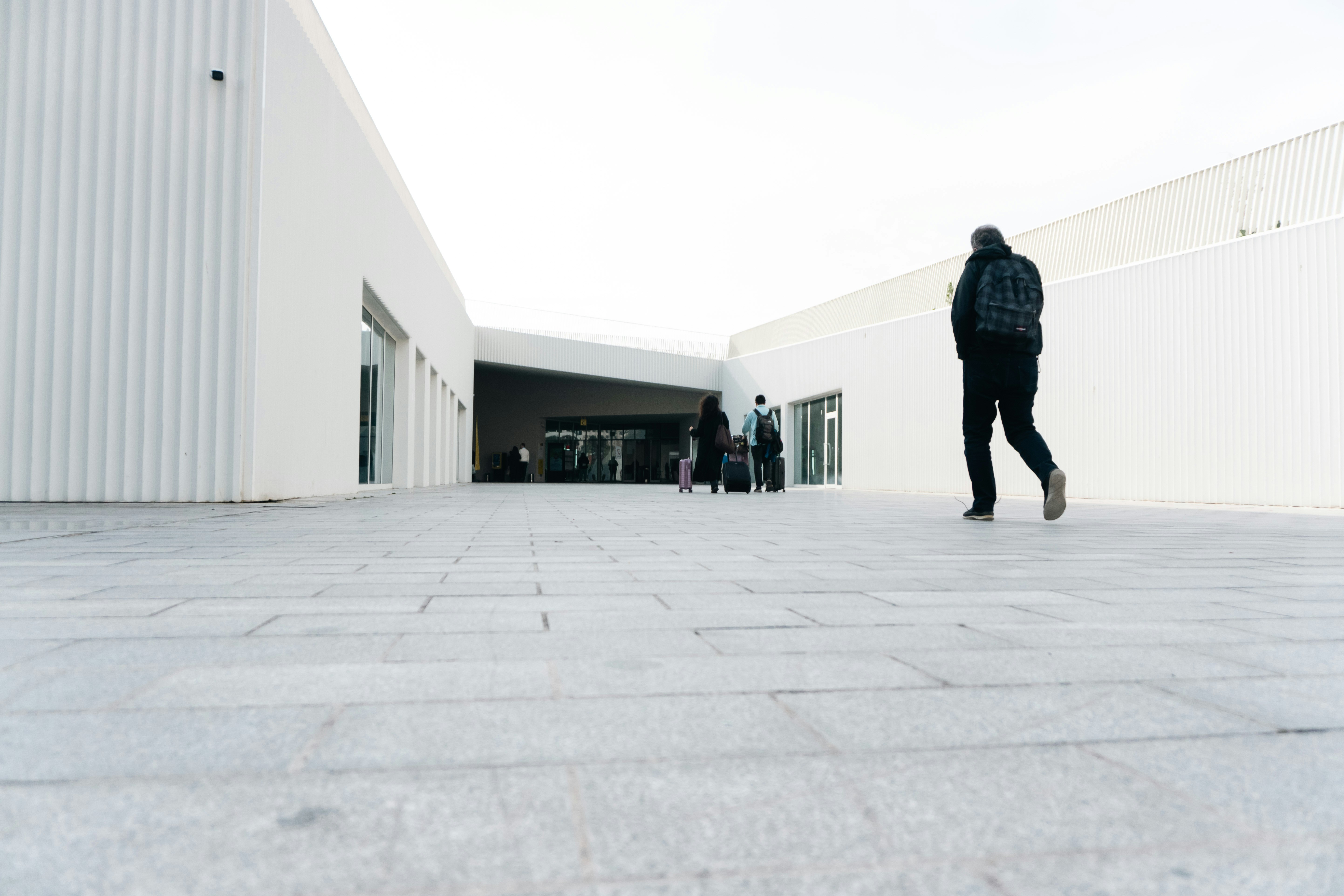 A person walks away from a modern white building.