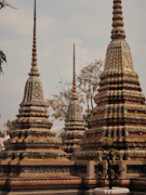 Ornate stupas at a temple with trees in background