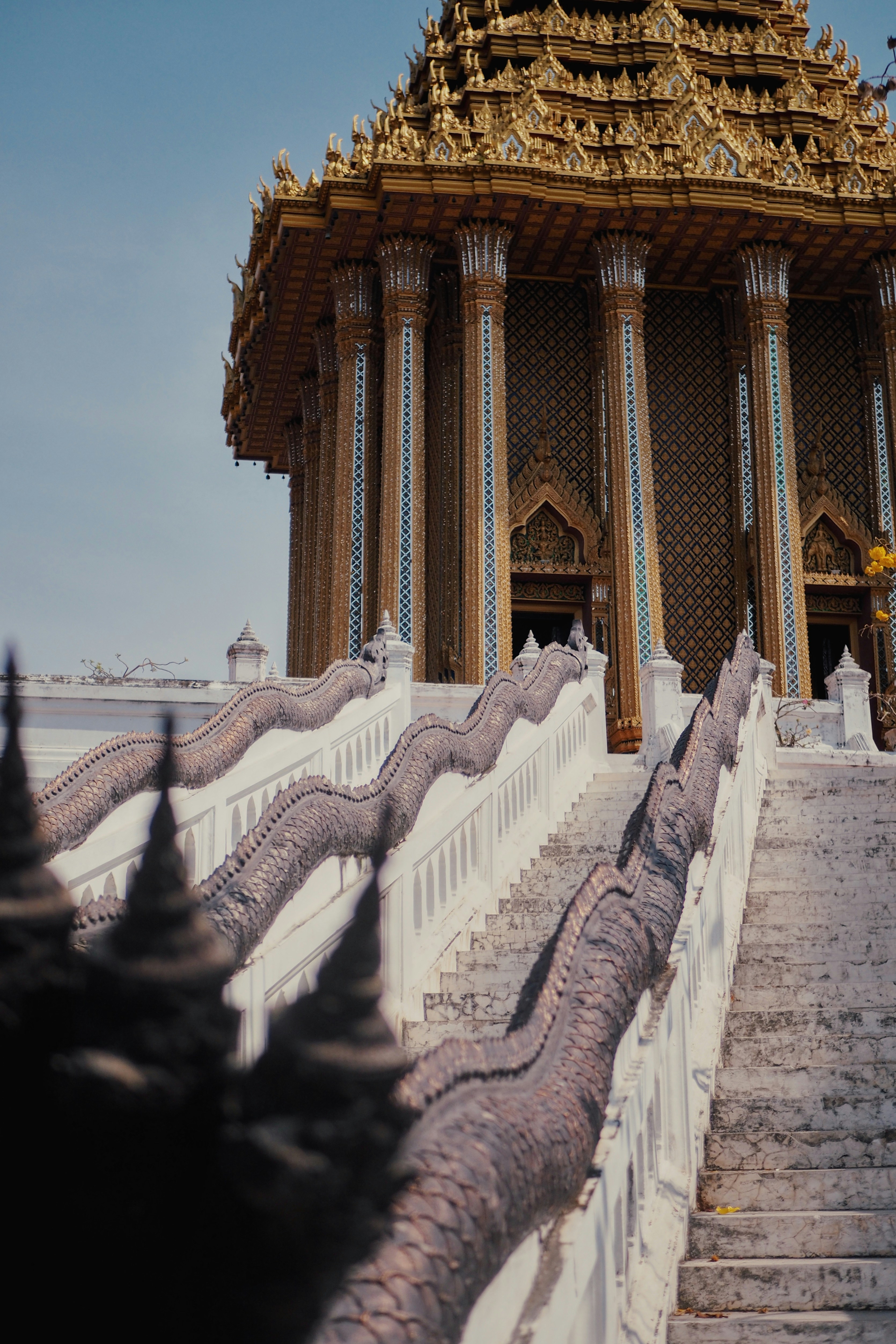 Ornate temple stairs with dragon railings and golden roof
