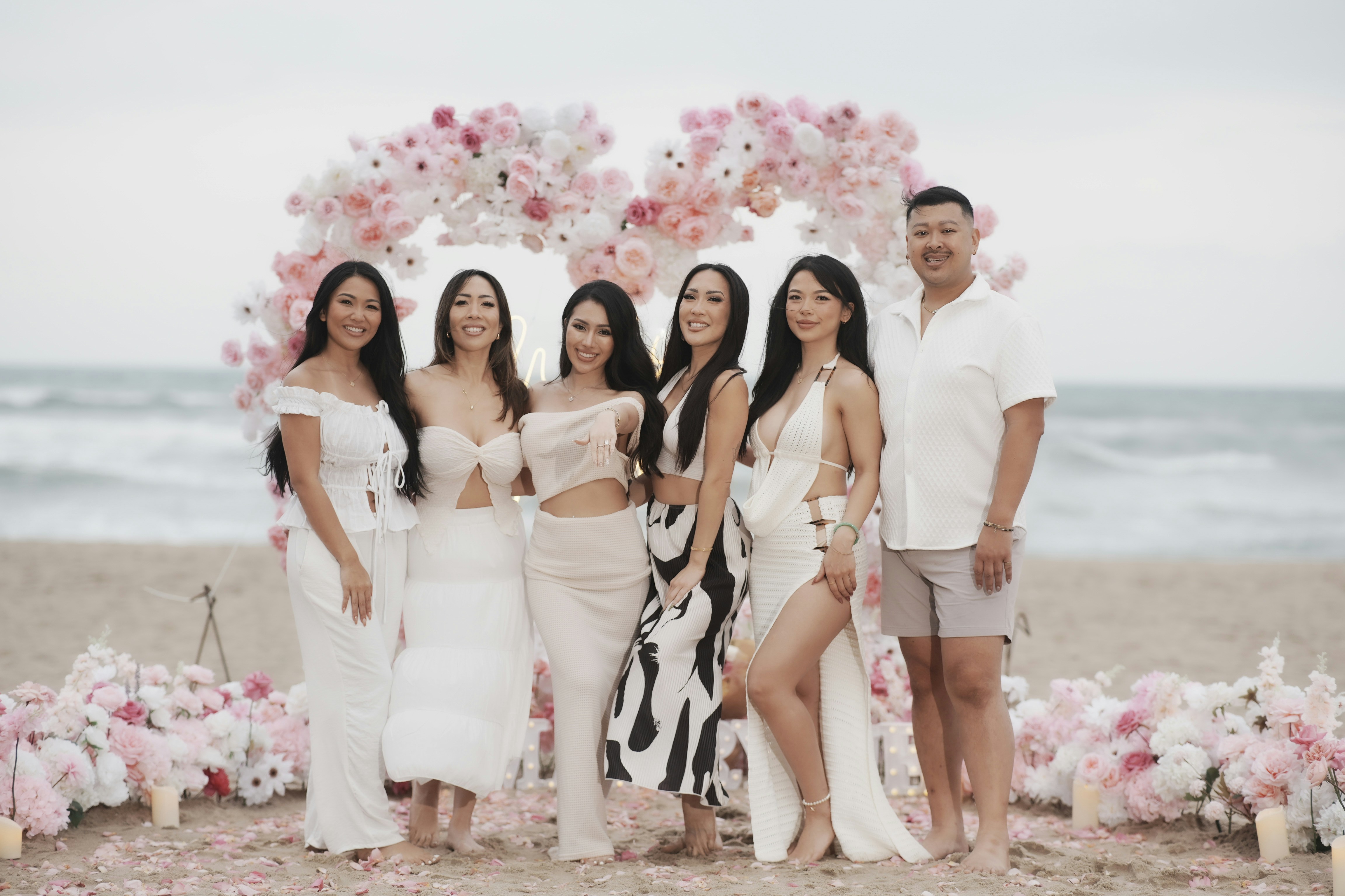A group of women and one man on a beach.