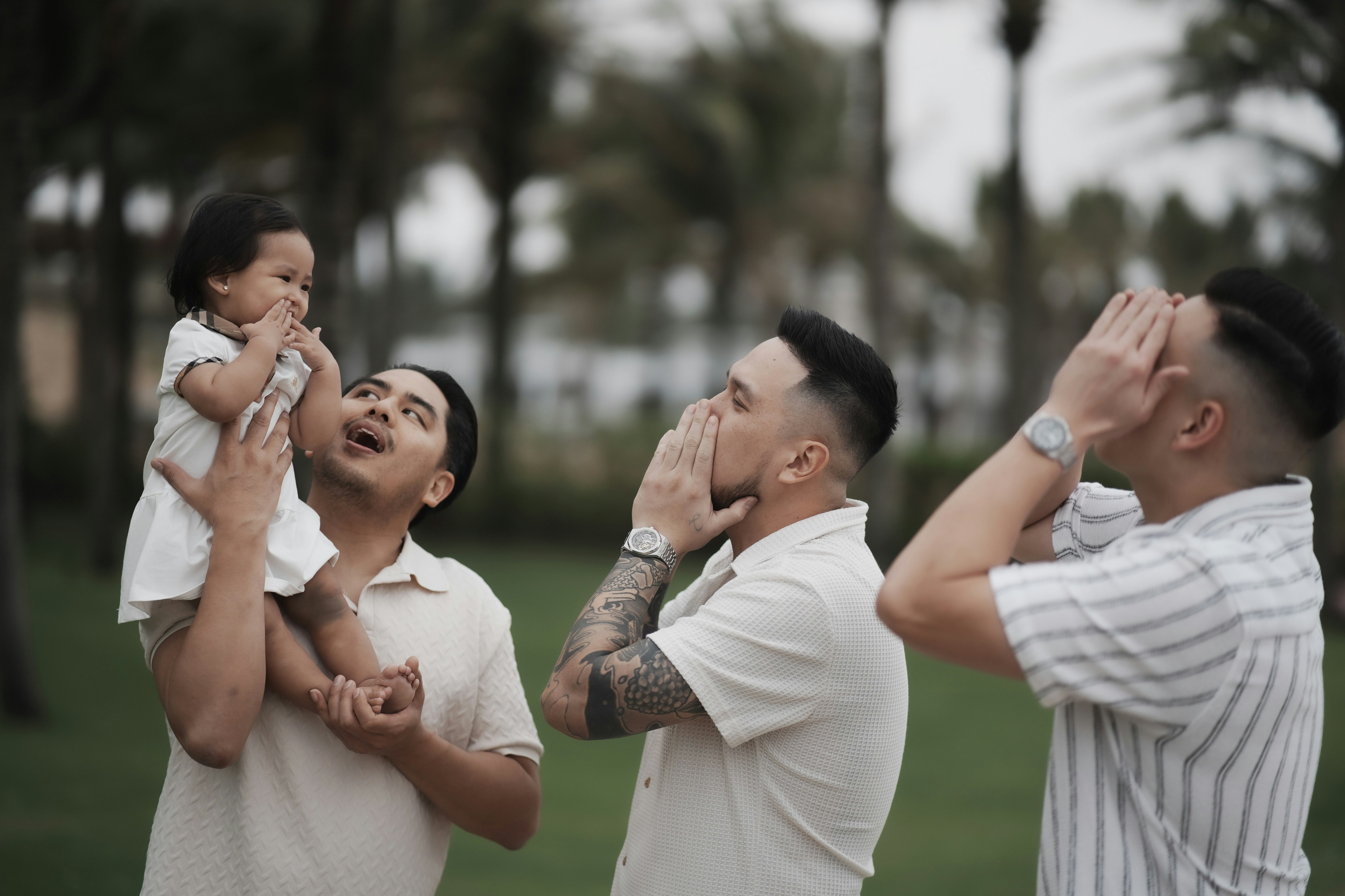 Three men and a baby playing outdoors