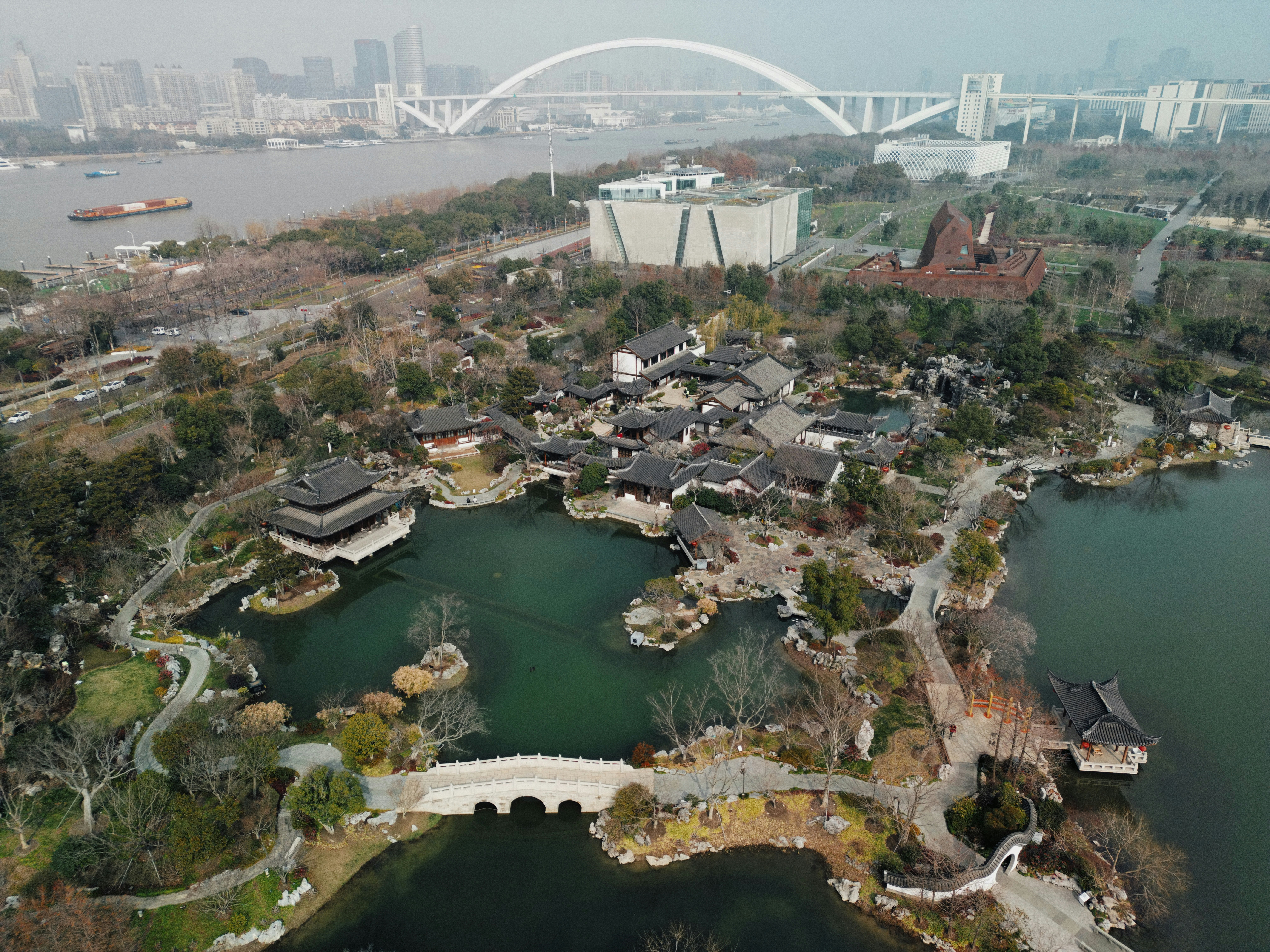 Aerial view of a traditional chinese garden with a bridge.