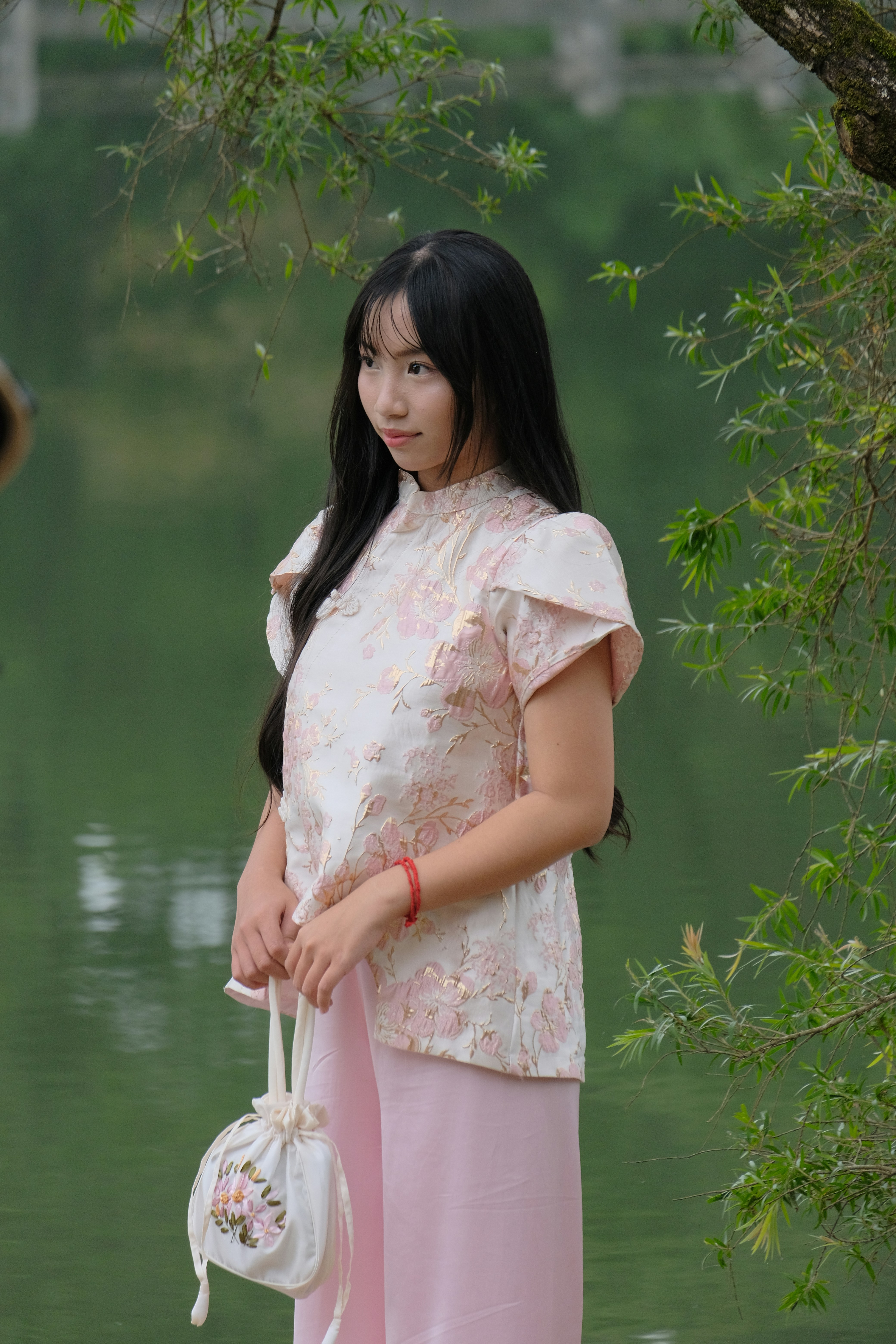 Young woman in traditional dress by a lake