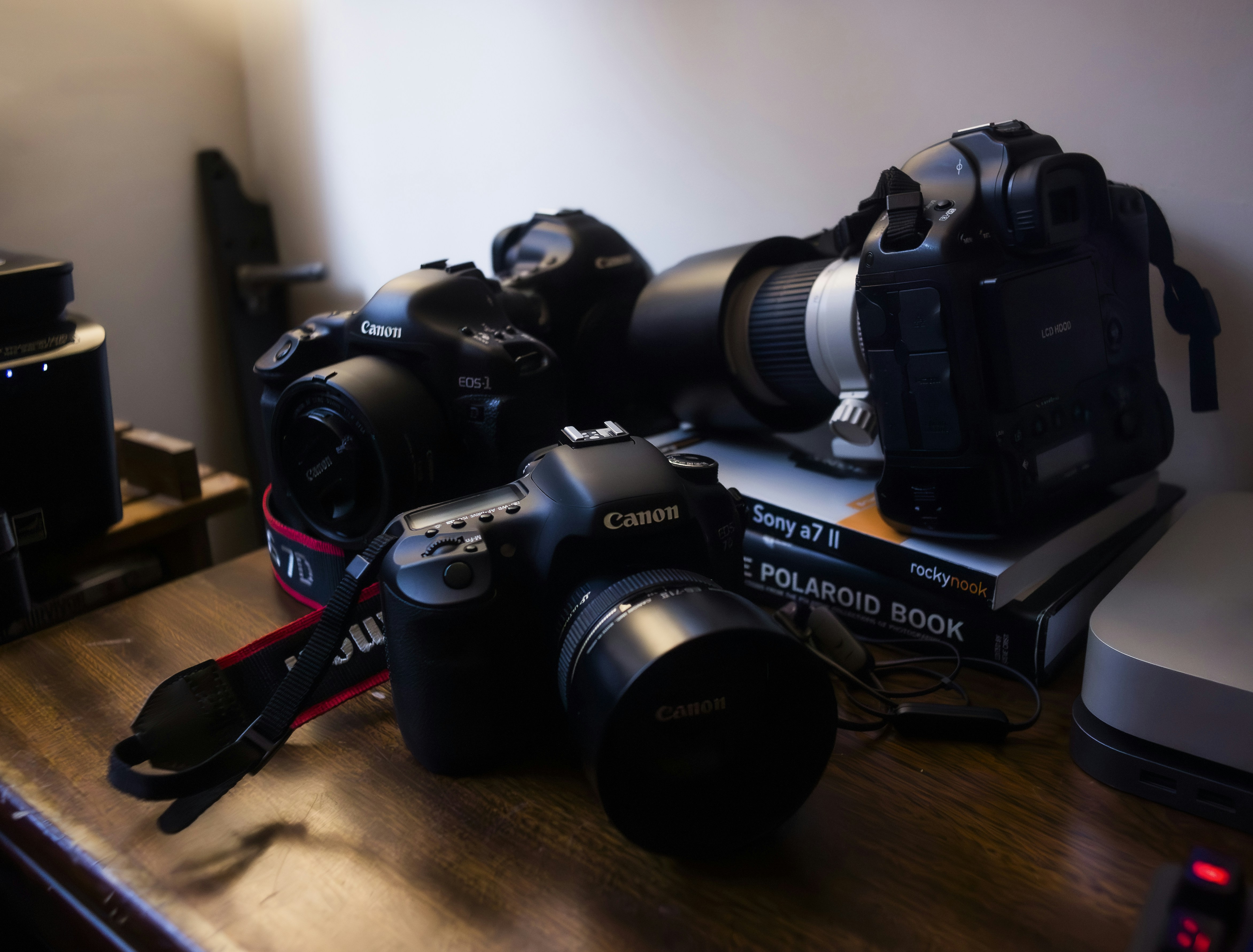 Several canon dslr cameras are arranged on a desk.