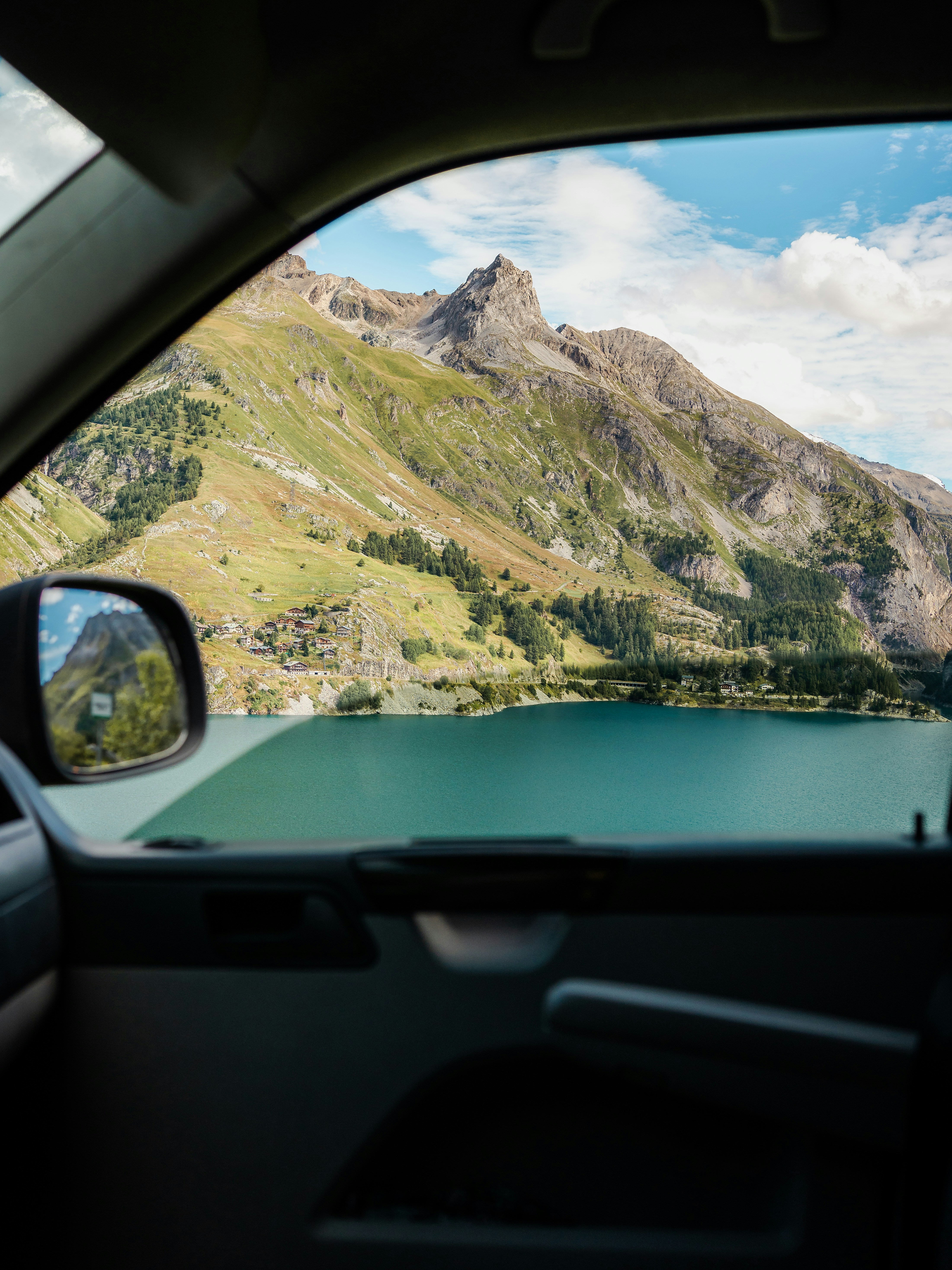 View of a mountain lake from inside a vehicle.