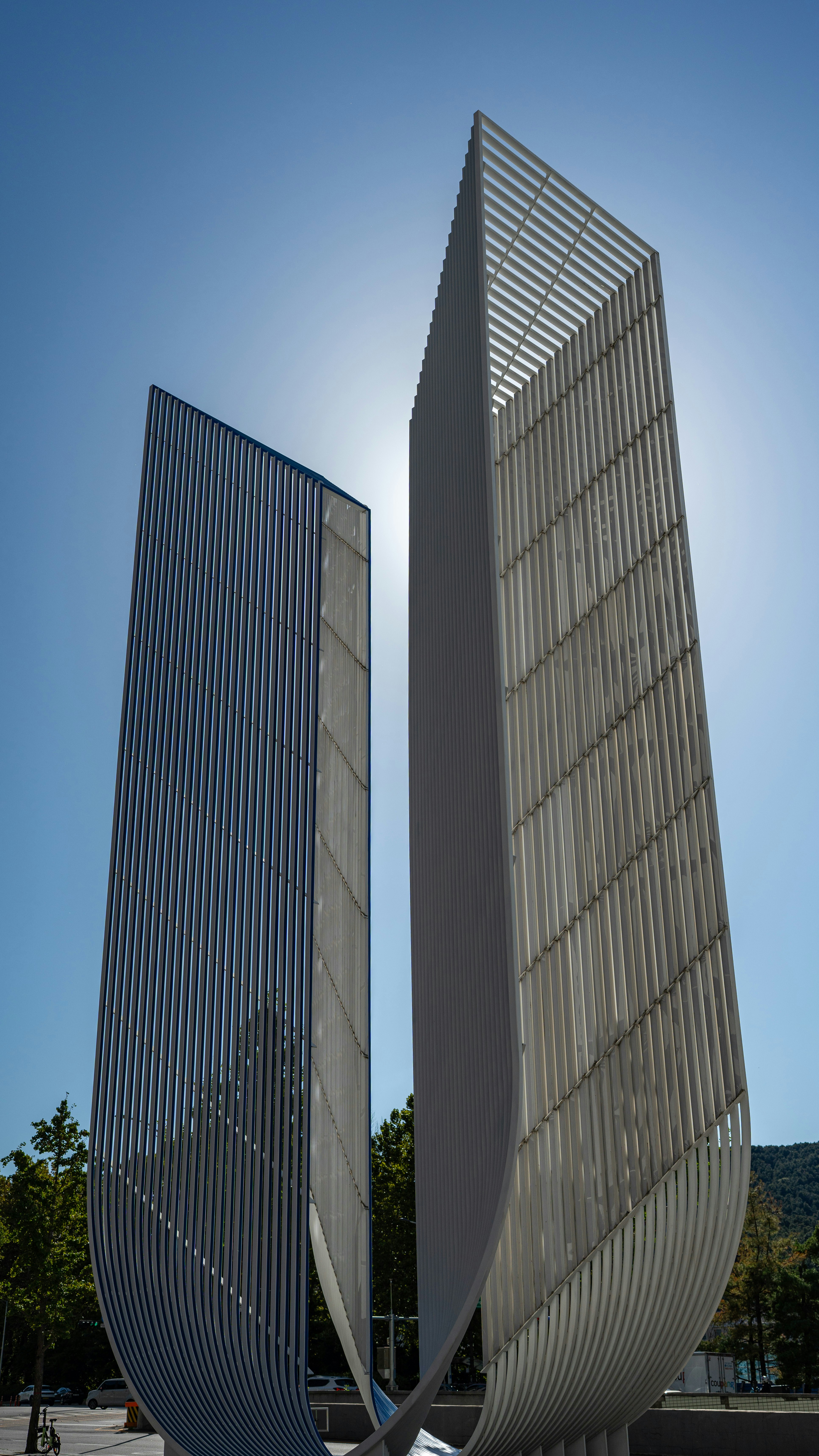 Due sculture moderne e alte contro un cielo azzurro brillante.