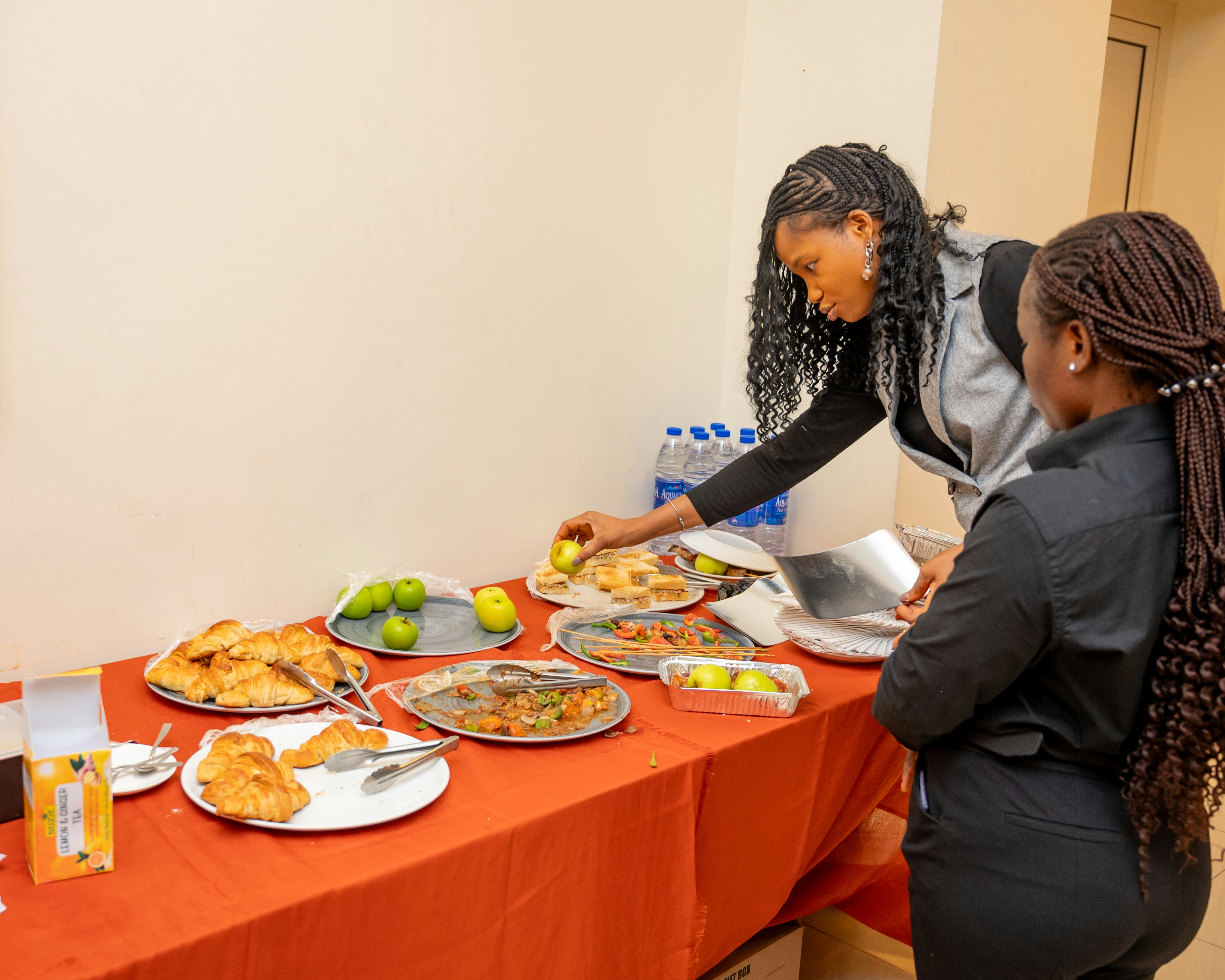 Due donne che scelgono cibo da un tavolo a buffet.