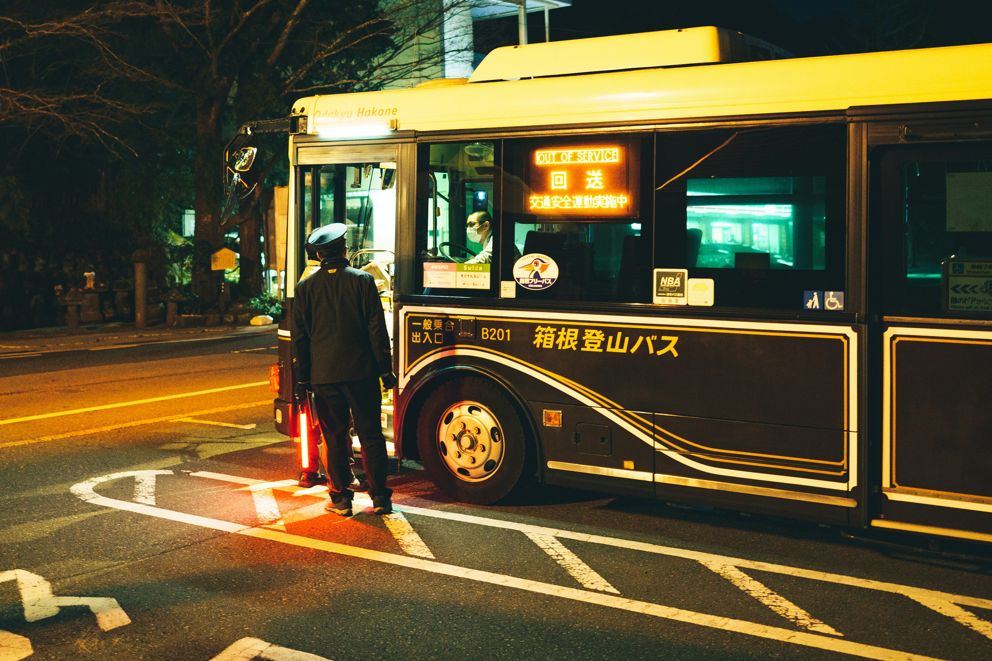 A person boarding a bus at night.