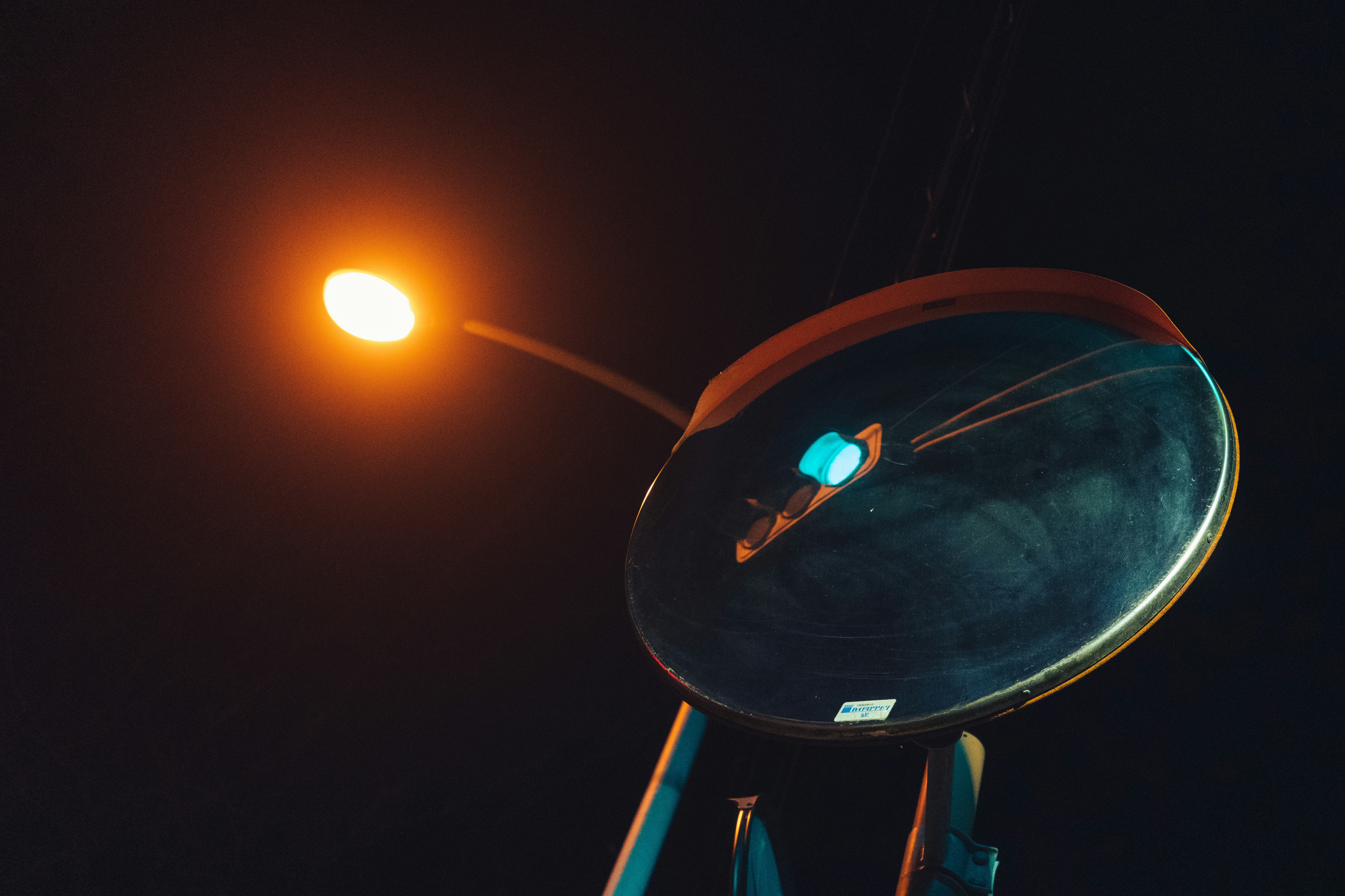 A street lamp illuminates a dark, circular object.