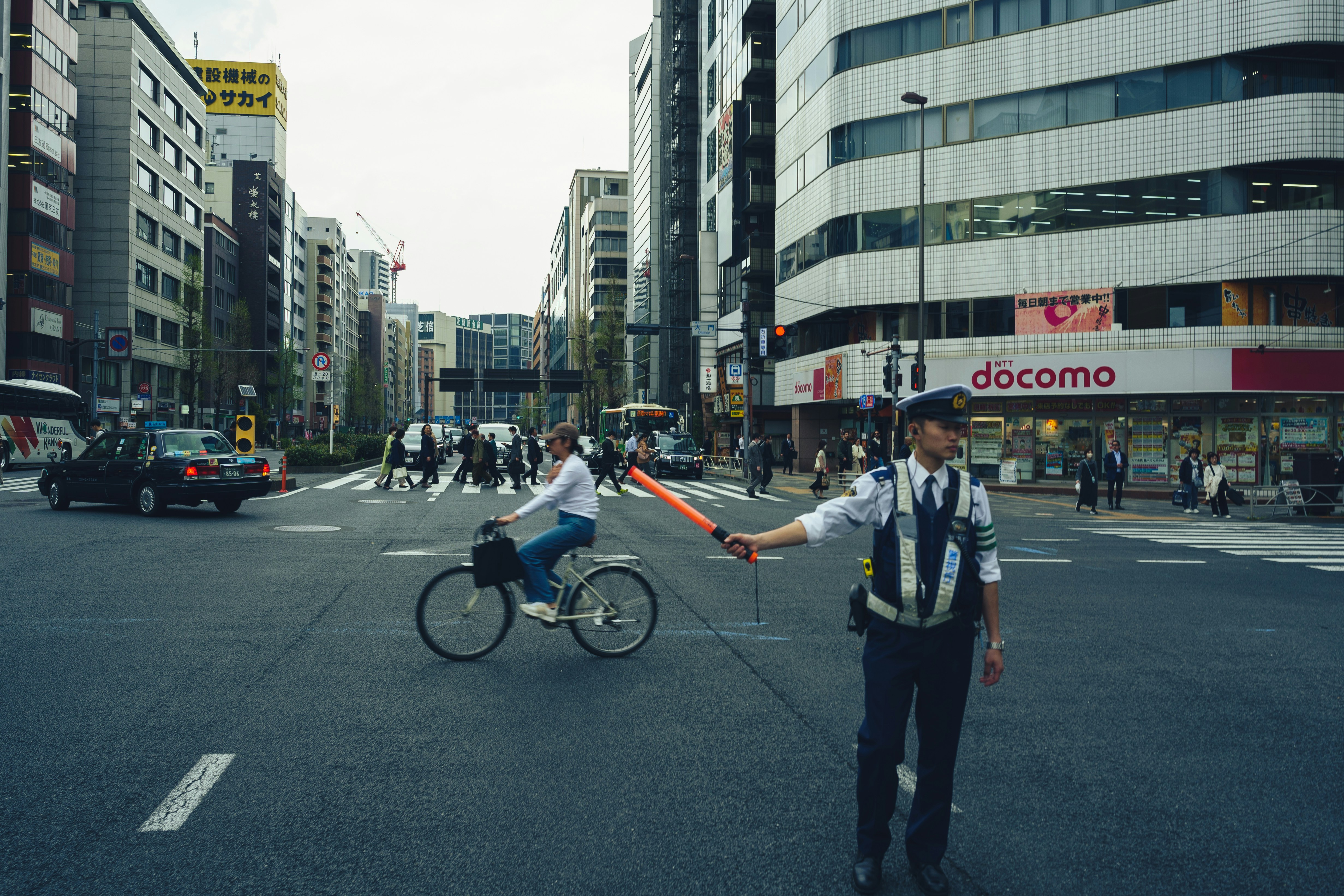 A traffic officer directs a cyclist at a busy intersection.