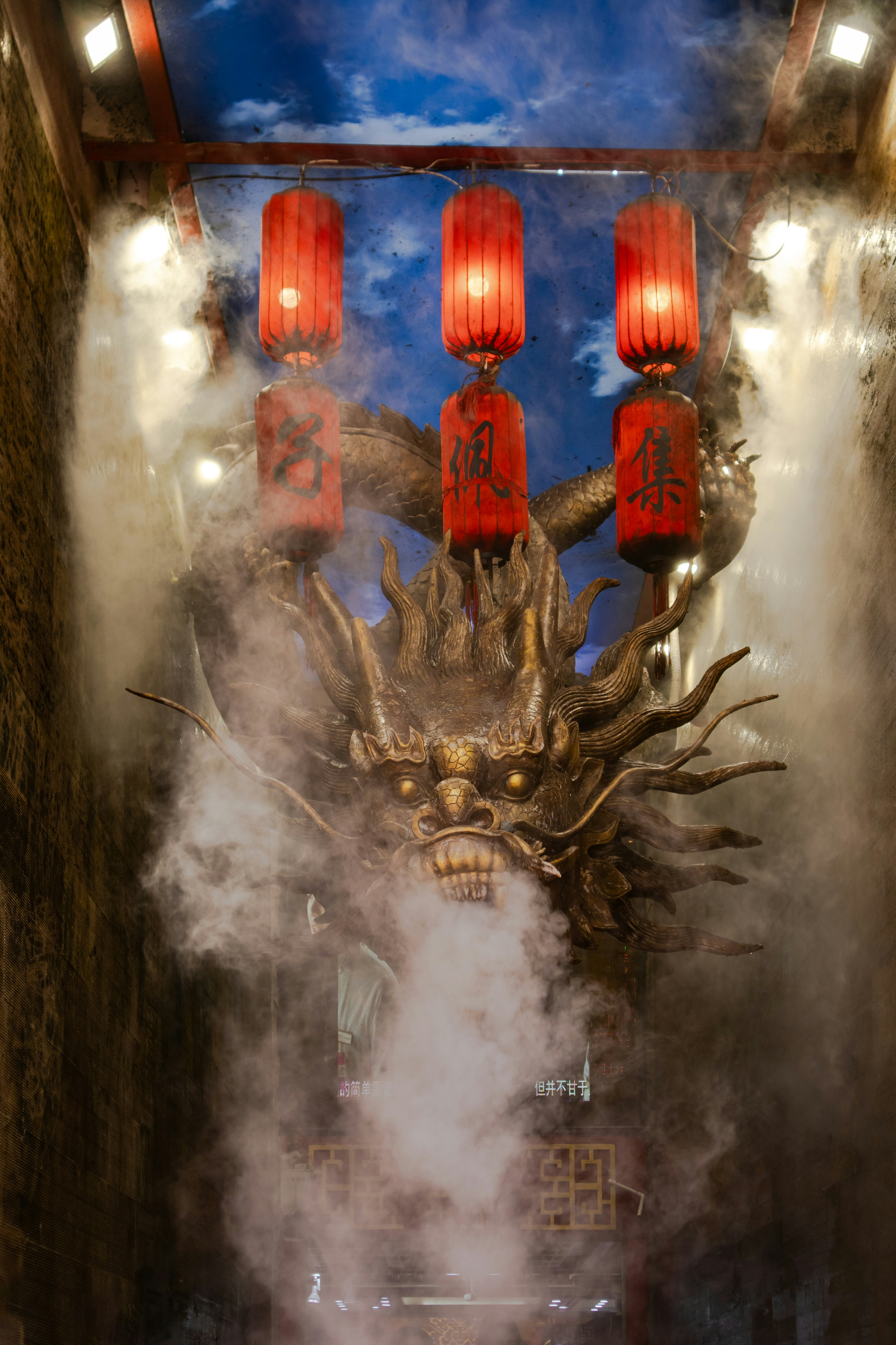 Dragon head sculpture with red lanterns and smoke