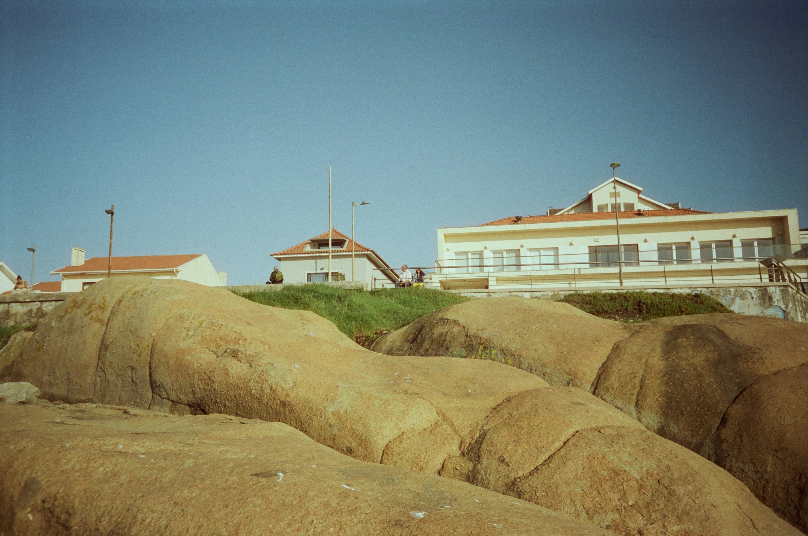 Buildings behind large rounded rocks under clear sky photo – Free ...