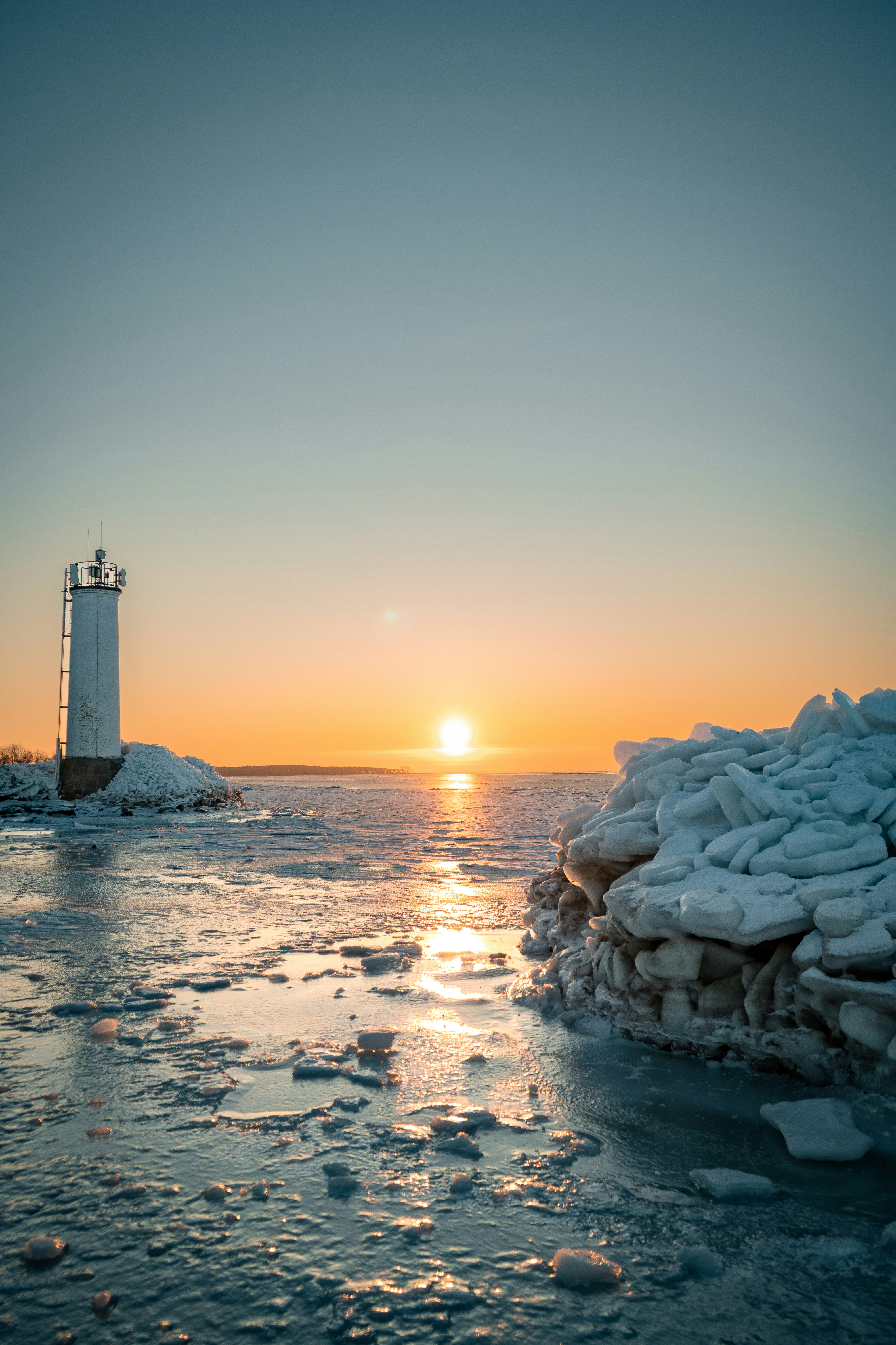 Lighthouse on a frozen coast at sunset