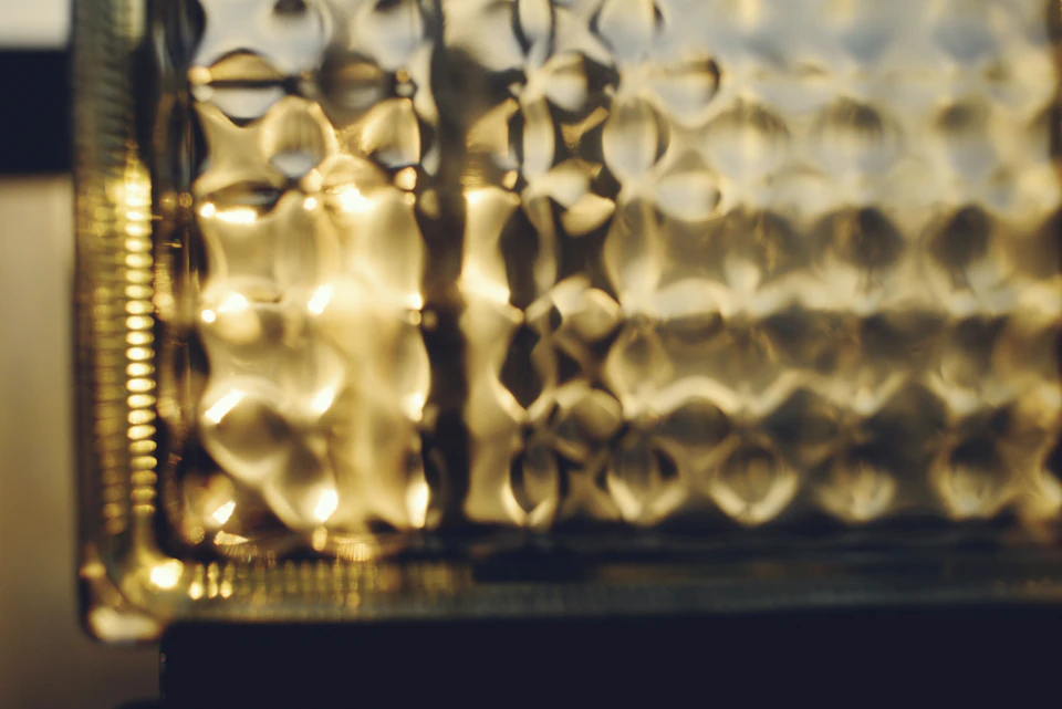 Close-up view of a glass surface with metallic sheen and small circular patterns