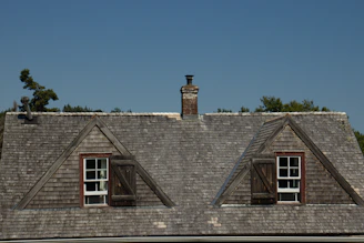 Two dormer windows on a shingled roof