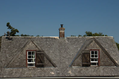 Two dormer windows on a shingled roof