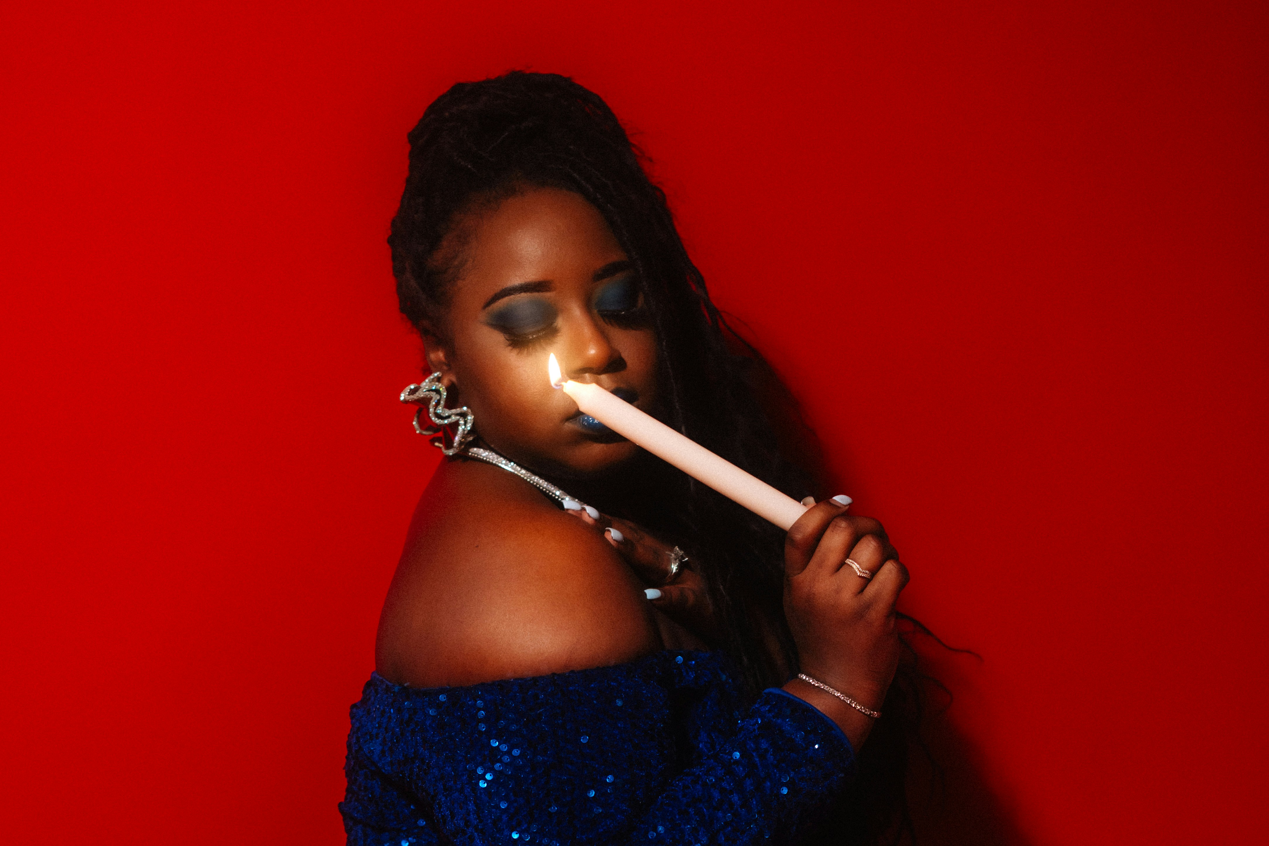 Woman holding a lit candle to her face