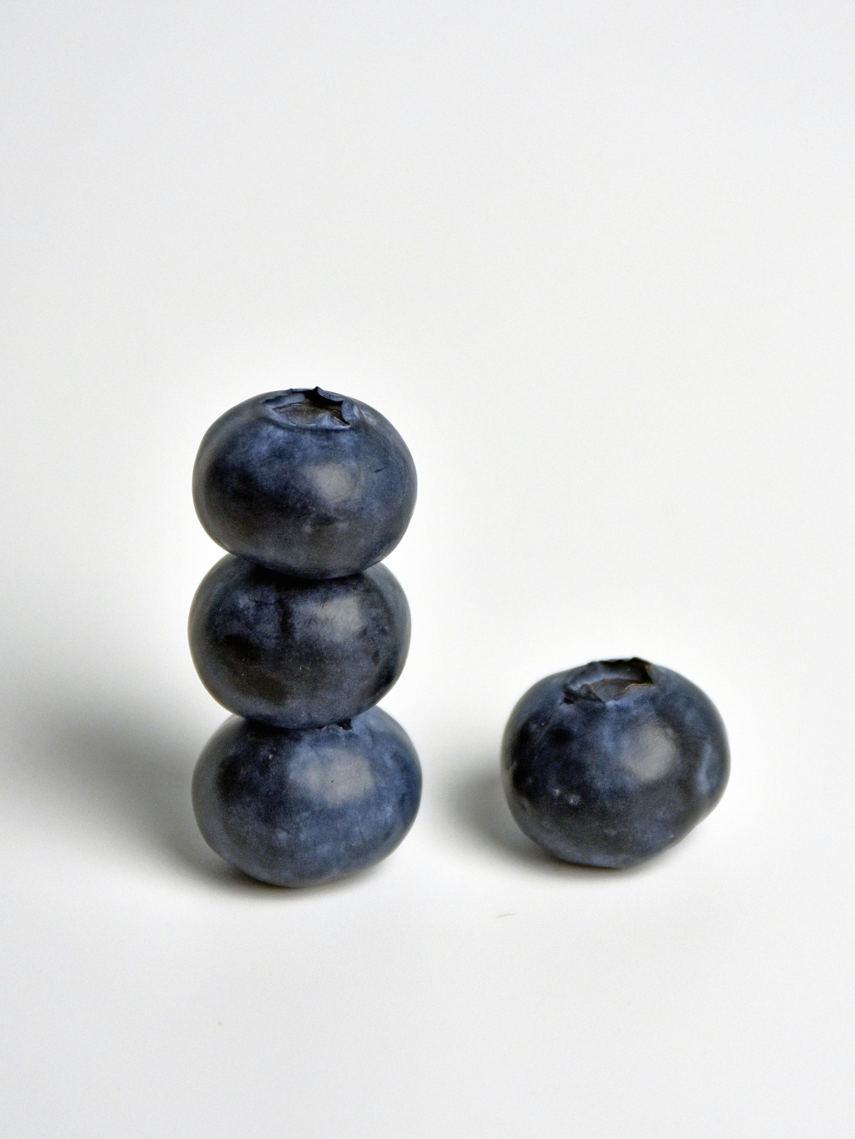 Three blueberries stacked with one beside them