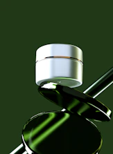 White cosmetic jar balanced on green reflective objects