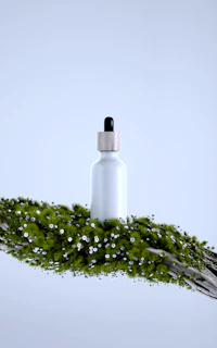 White bottle with dropper on mossy branch with flowers