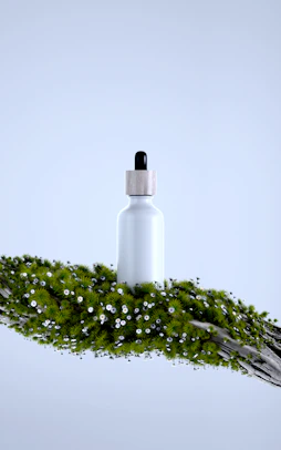 White bottle with dropper on mossy branch with flowers